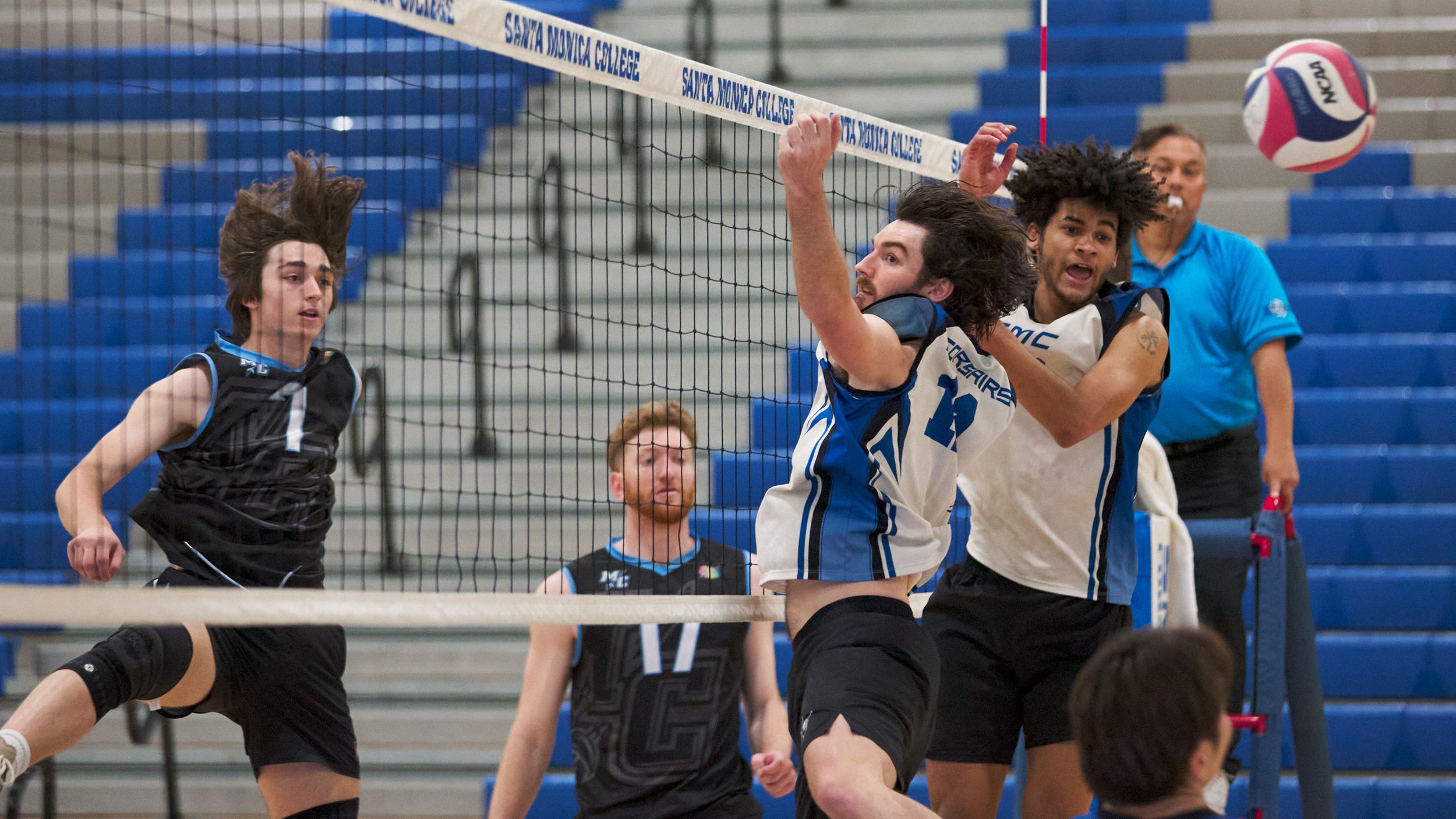  Moorpark College Raiders' Oliver Herron hits the ball past Santa Monica College Corsairs' Jonathan Pritchard and Nate Davis during the men's volleyball match on Wednesday, April 12, 2023, at Corsair Gym in Santa Monica, Calif. The Corsairs lost 3-0.