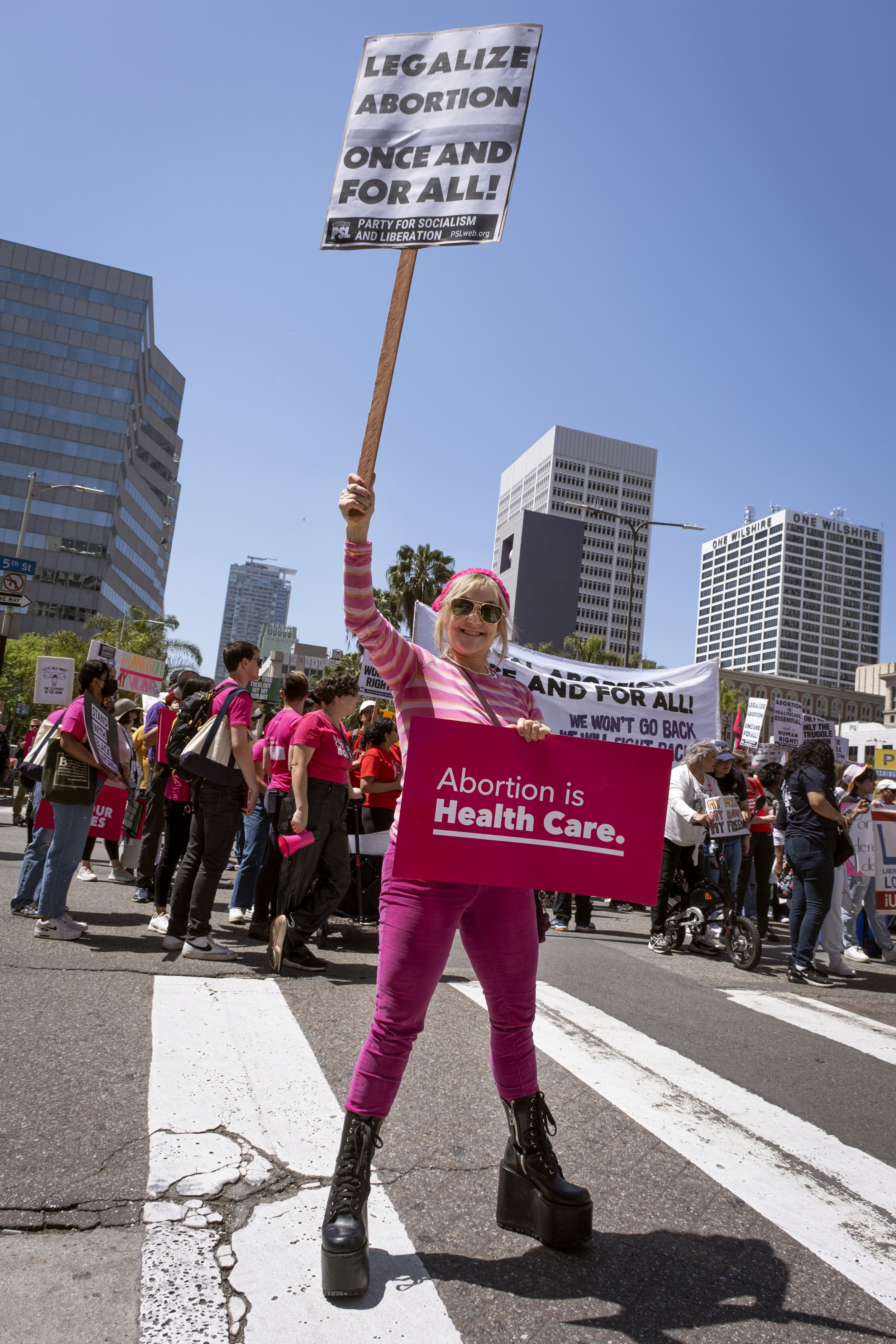 Cynthia Fisher, a demonstrator, holds signs at the Women’s March gathering at Pershing Square in Los Angeles, Calif. on Saturday, April 15, 2023.  (Anna Sophia Moltke | The Corsair) 