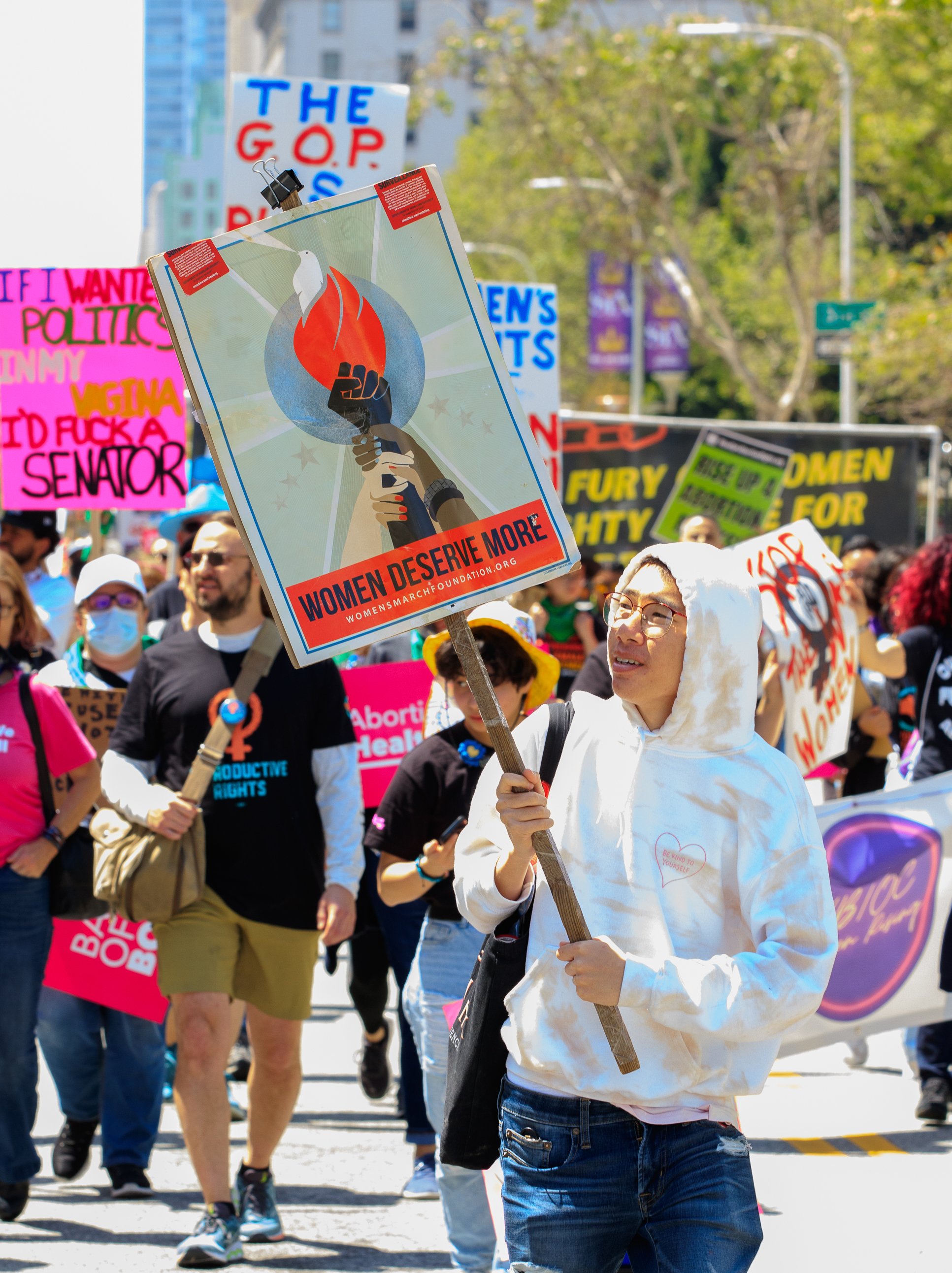  Protester, Kevin Is holding up a sign and walking with Women's March Foundation and other organizations to Los Angeles City Hall, April 15, 2023. (Alejandro Contreras | The Corsair) 