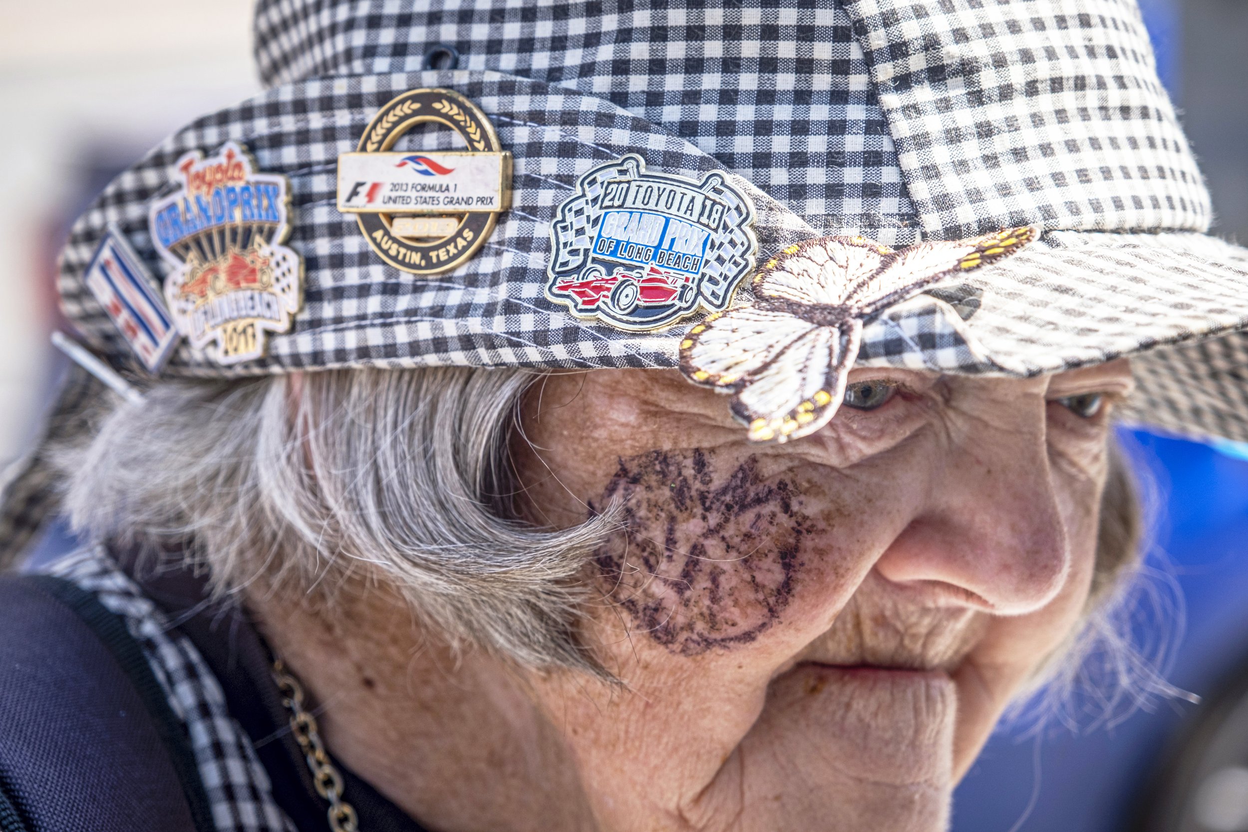  George-Lyn wears her “Grand Prix outfit” and sports pins of past races on her hat. Ocean Boulevard outside of the 48th Annual Acura Grand Prix in Long Beach, Calif. on Sat., April 15, 2023. (Anna Sophia Moltke | The Corsair) 
