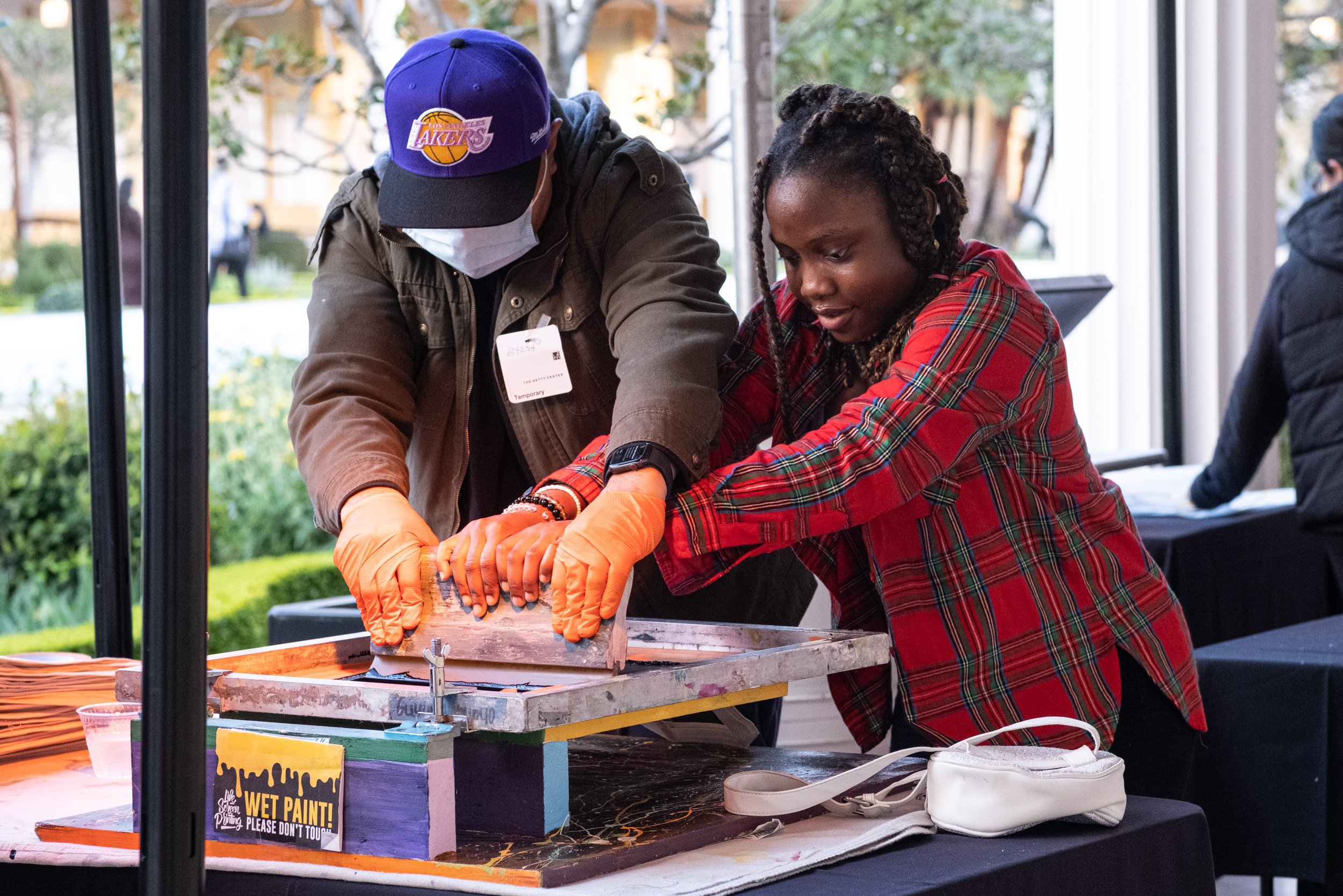  Daniella Pat-Onuoha, Biochemistry and Molecular Biology major at California Lutheran University silk screens a design onto a tote bag at College Night on Wednesday, March 22, 2023. at the Getty Villa Museum in Pacific Palisades, Calif. (Akemi Rico |