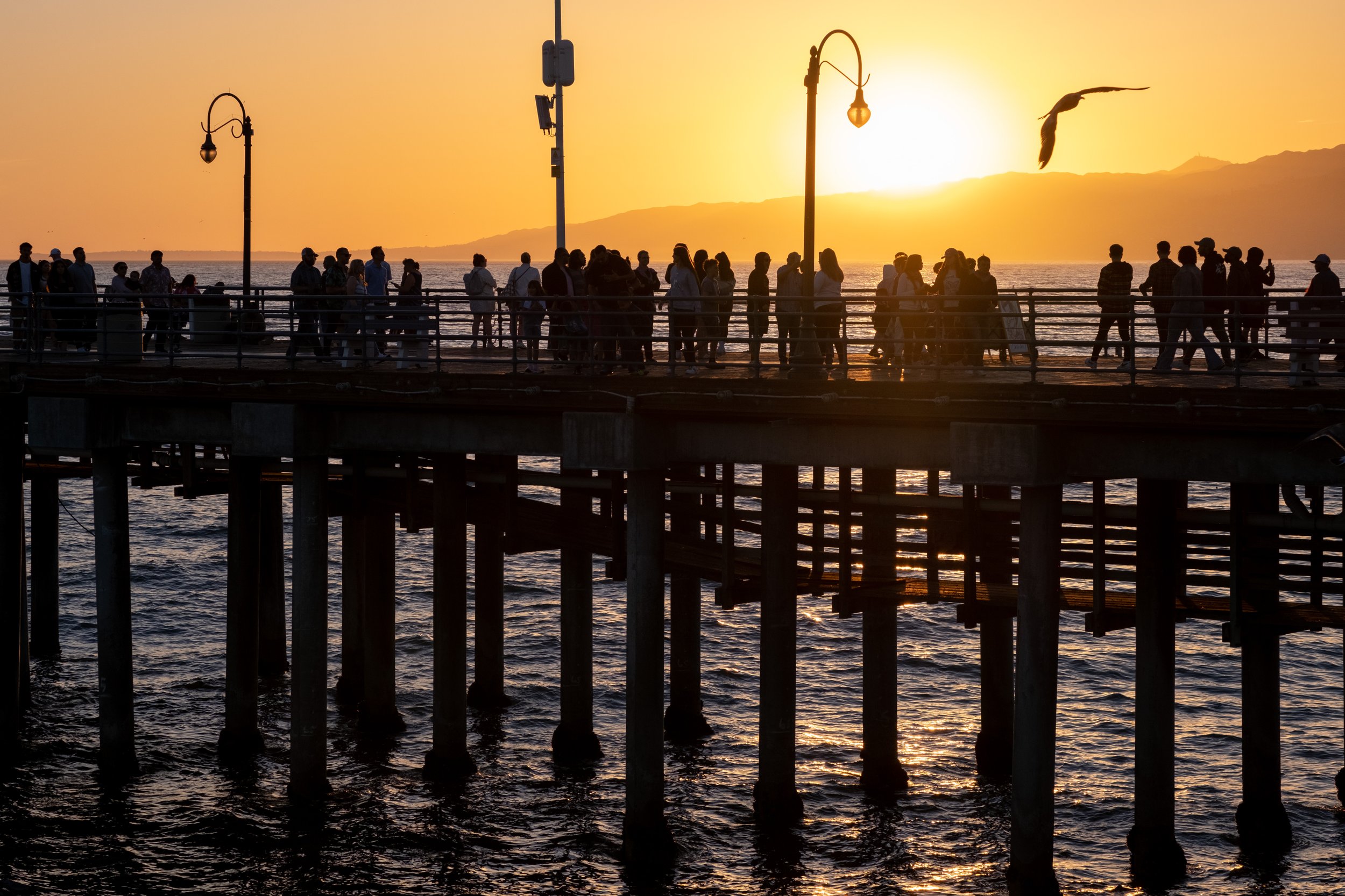  People watching the sun set on Thursday, April 20, 2023. Santa Monica Pier in Santa Monica, Calif. hosts Locals' Night every third Thursday with free programming from 4:00pm to 10:00pm.  (Akemi Rico | The Corsair) 