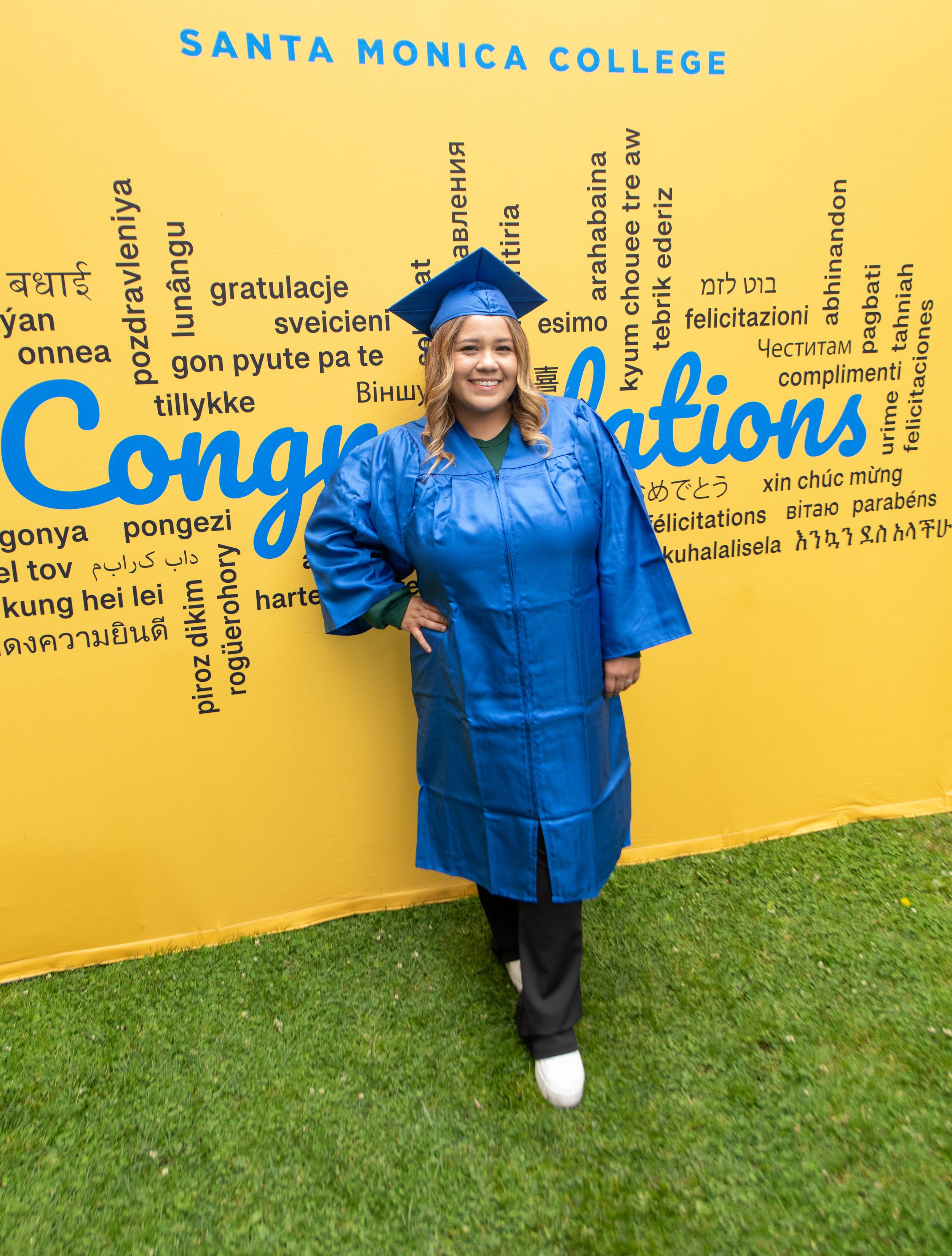  Student Jennifer Medrano poses in front of the background set up for graduates at Grad Fest Thursday, June 1 at Santa Monica College Main Quad ( Kevin Tidmore | TheCorsair ) 