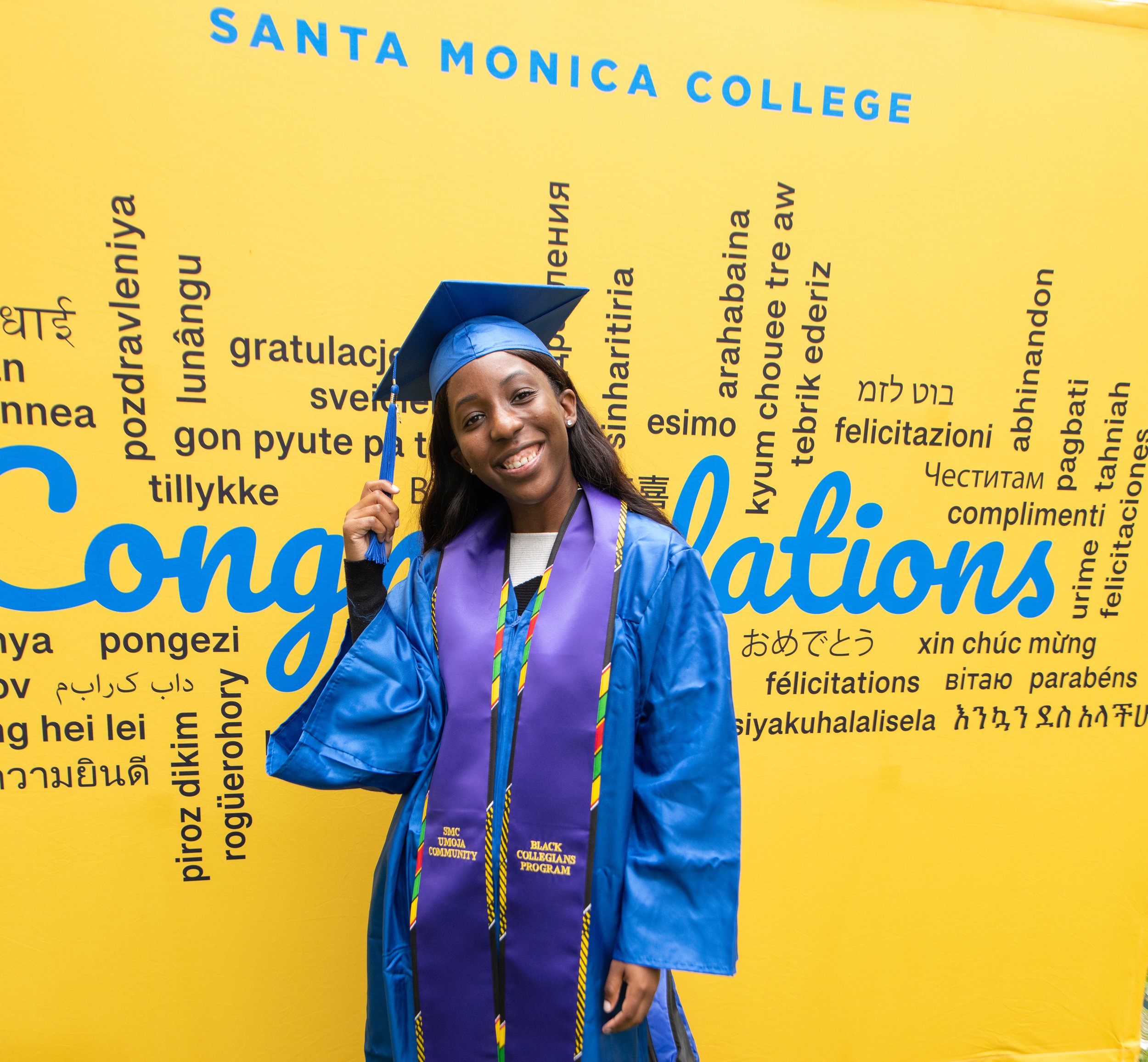  Student Monique Johnson poses in front of the background set up for graduates at Grad Fest Thursday, June 1 at Santa Monica College Main Quad ( Kevin Tidmore | TheCorsair ) 