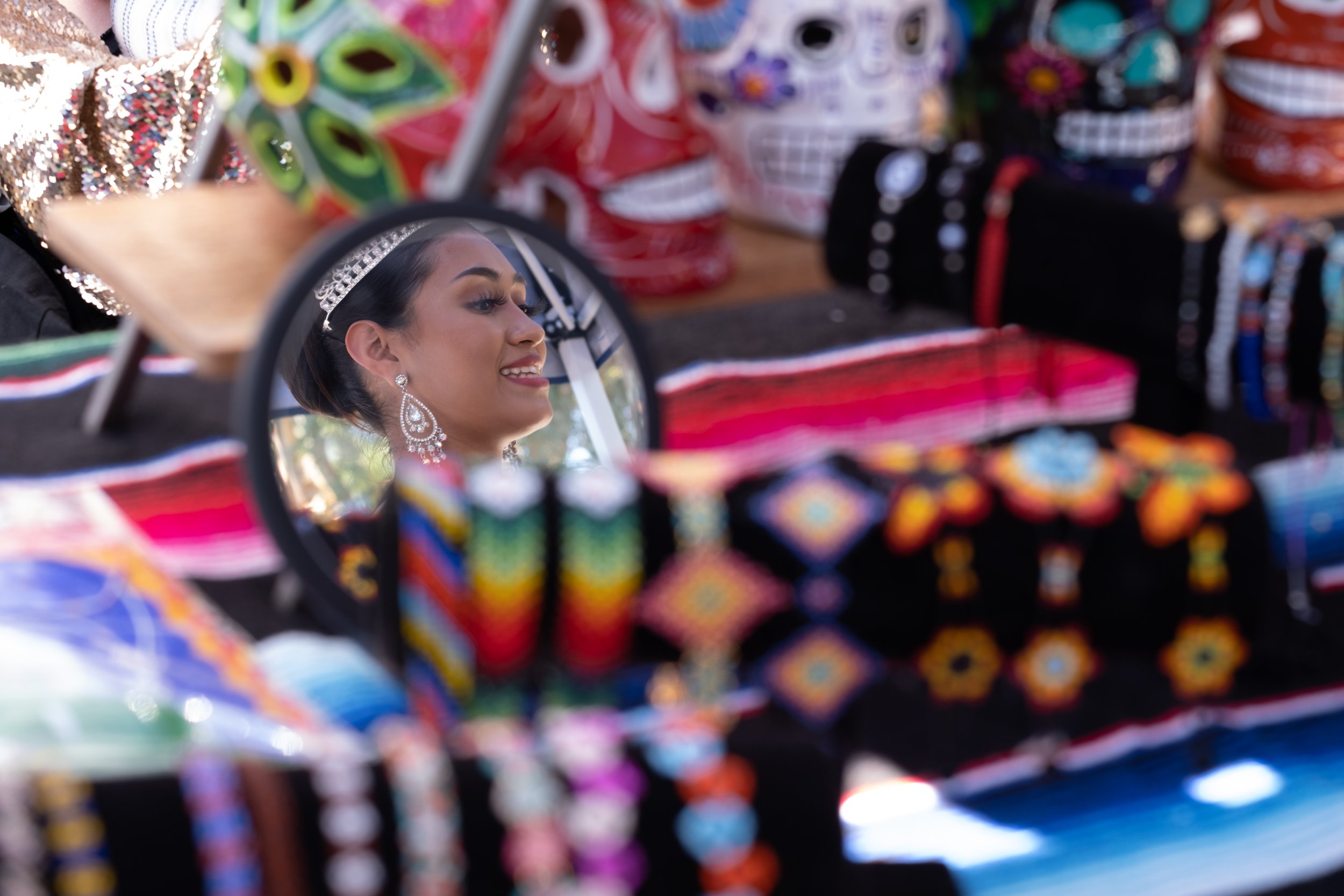  Reina Fiestas Patrias Frida Megia's reflection is seen in a hand mirror as she browses jewelry at vendor Hazel Rios' booth, "Curios Mirabelle" at the annual East Los Angeles Mexican Independence Day Festival, held on Sunday, Sept. 10th, 2023. (Akemi