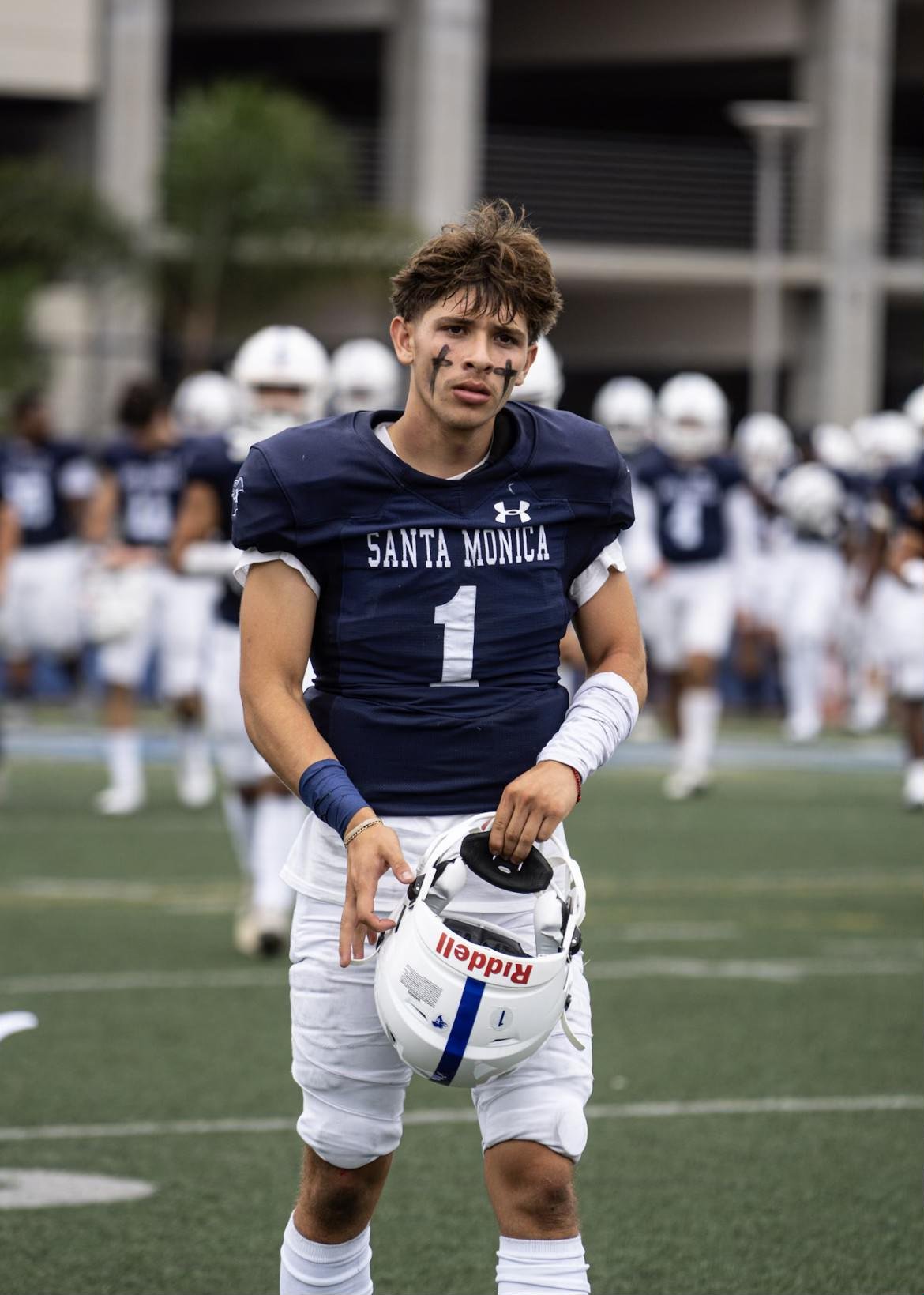  Quarterback Dylan Moreno stands with his helmet off showing his double-cross face paint. [Photo credit: Amari Yolas.] 