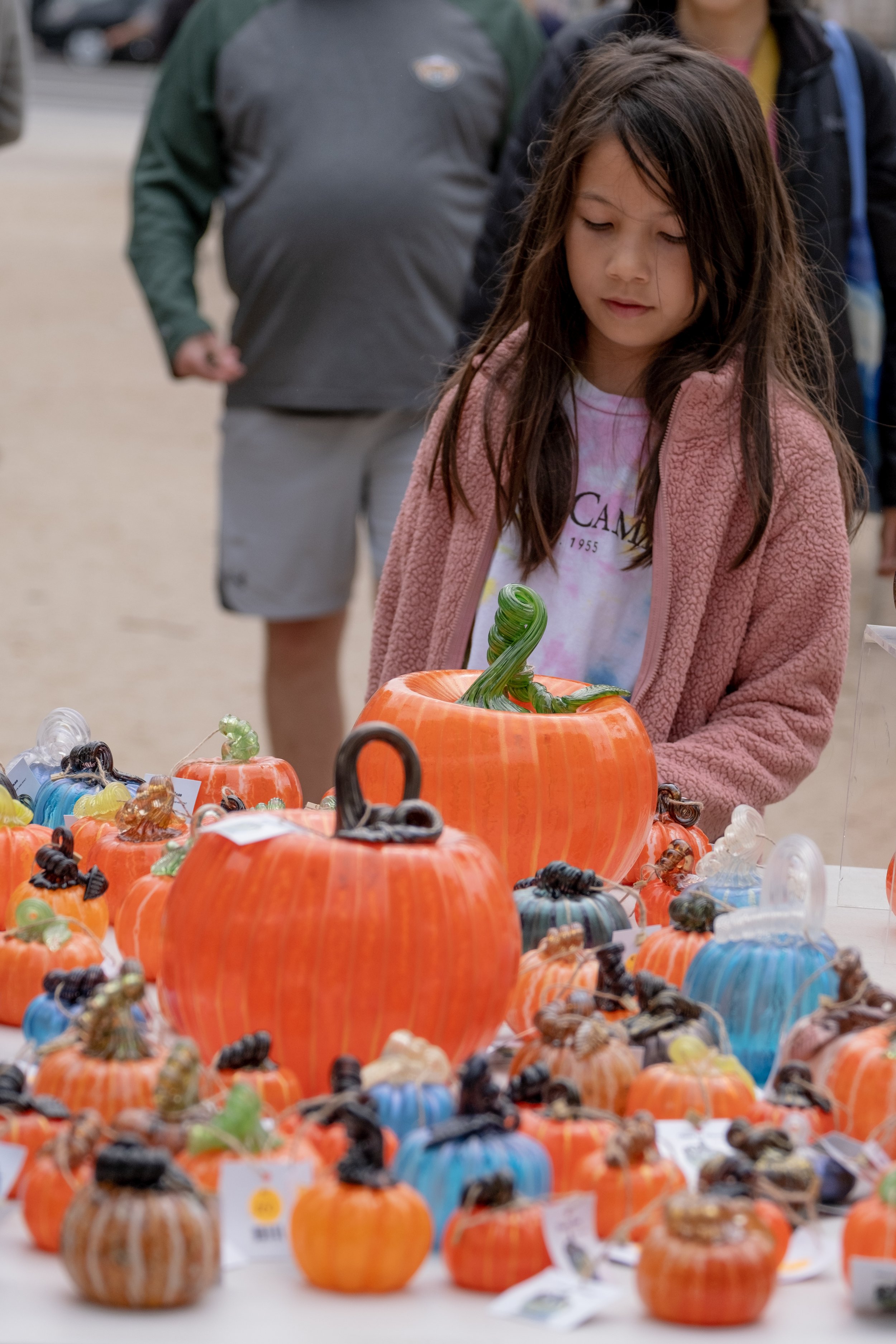  Malin Anderson, a young Santa Monica local checks out the pumpkins made of glass on the display tables at the Santa Monica College Glass Pumpkin Sale in Virginia Avenue Park in Santa Monica, Calif. on Saturday, Sept. 30th, 2023. (Akemi Rico | The Co