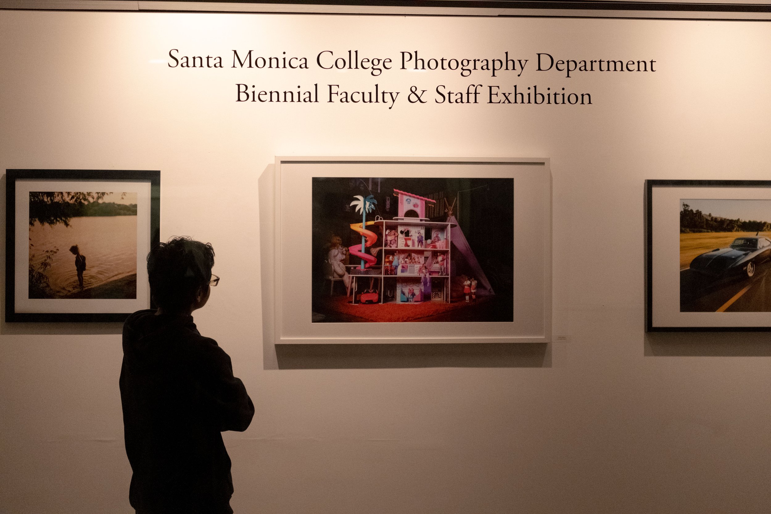  Photography student Kevin Mendoza observing the photos displayed in Drescher Hall, 2nd floor, at the Santa Monica College main campus in Santa Monica, Calif. at the opening reception of the annual Faculty & Staff Exhibition and Silent Auction Fundra
