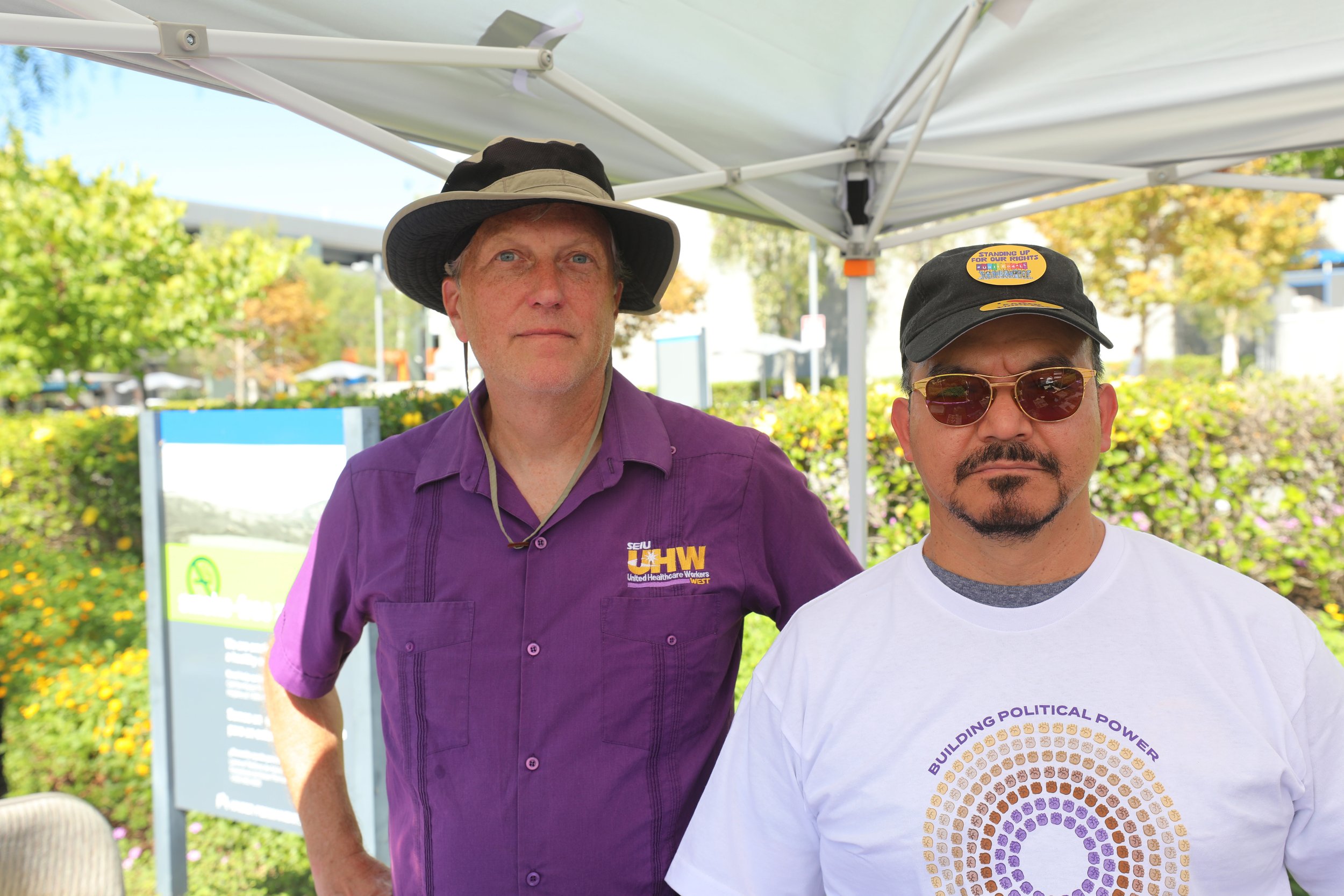    Union Researcher Tim Sundeen and Kaiser Medical Assistant Jose Najera stand at their table to register and support workers participating in the three-day Kaiser strike on October 6, 2023 at the Kaiser Permanente Los Angeles Medical Center (Renee B