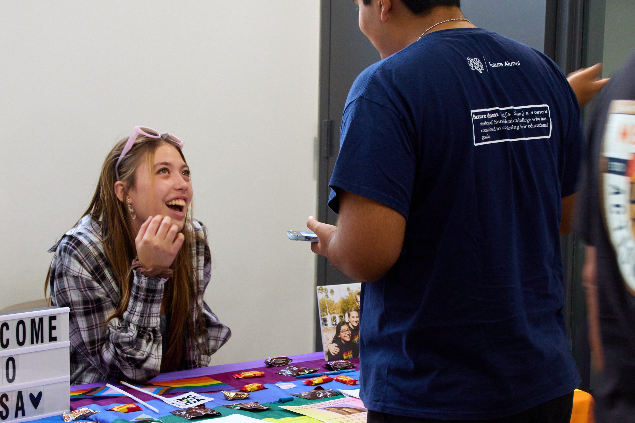  Santa Monica College (SMC) Gender Sexuality Alliance (GSA) member Amelia Fusch speaks to a student about GSA at the grand opening of the Student Equity Center at SMC main campus, Santa Monica, Calif., on Oct 5, 2023. (Danniel Sumarkho | The Corsair)
