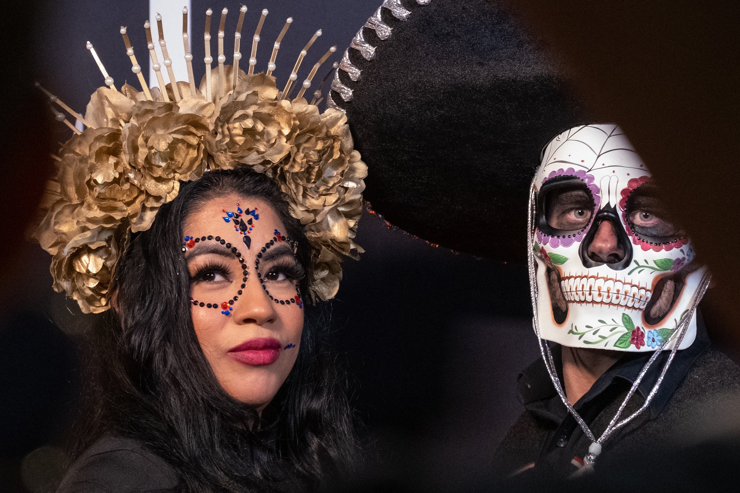  A couple pose in front of the step and repeat banner at the entrance to El Velorio's 13th Day of the Dead Music & Arts Festival at La Plaza de la Raza, Los Angeles, Calif. on Saturday Oct. 14, 2023. (Akemi Rico | The Corsair) 