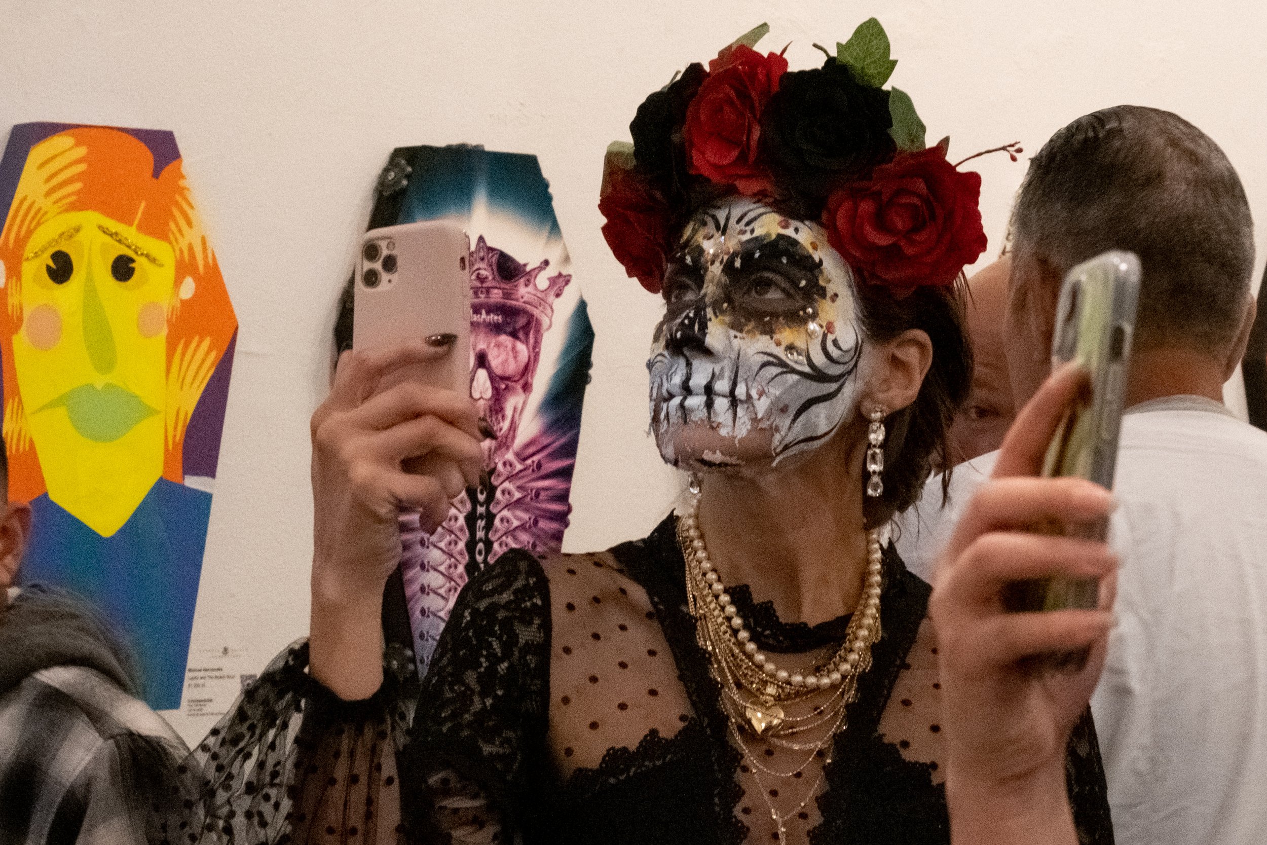  A woman dressed as a Catrina stands in front of the artist exhibits and takes pictures of the art at El Velorio's 13th Day of the Dead Music & Arts Festival at La Plaza de la Raza, Los Angeles, Calif. on Saturday Oct. 14, 2023. The art show was a tr