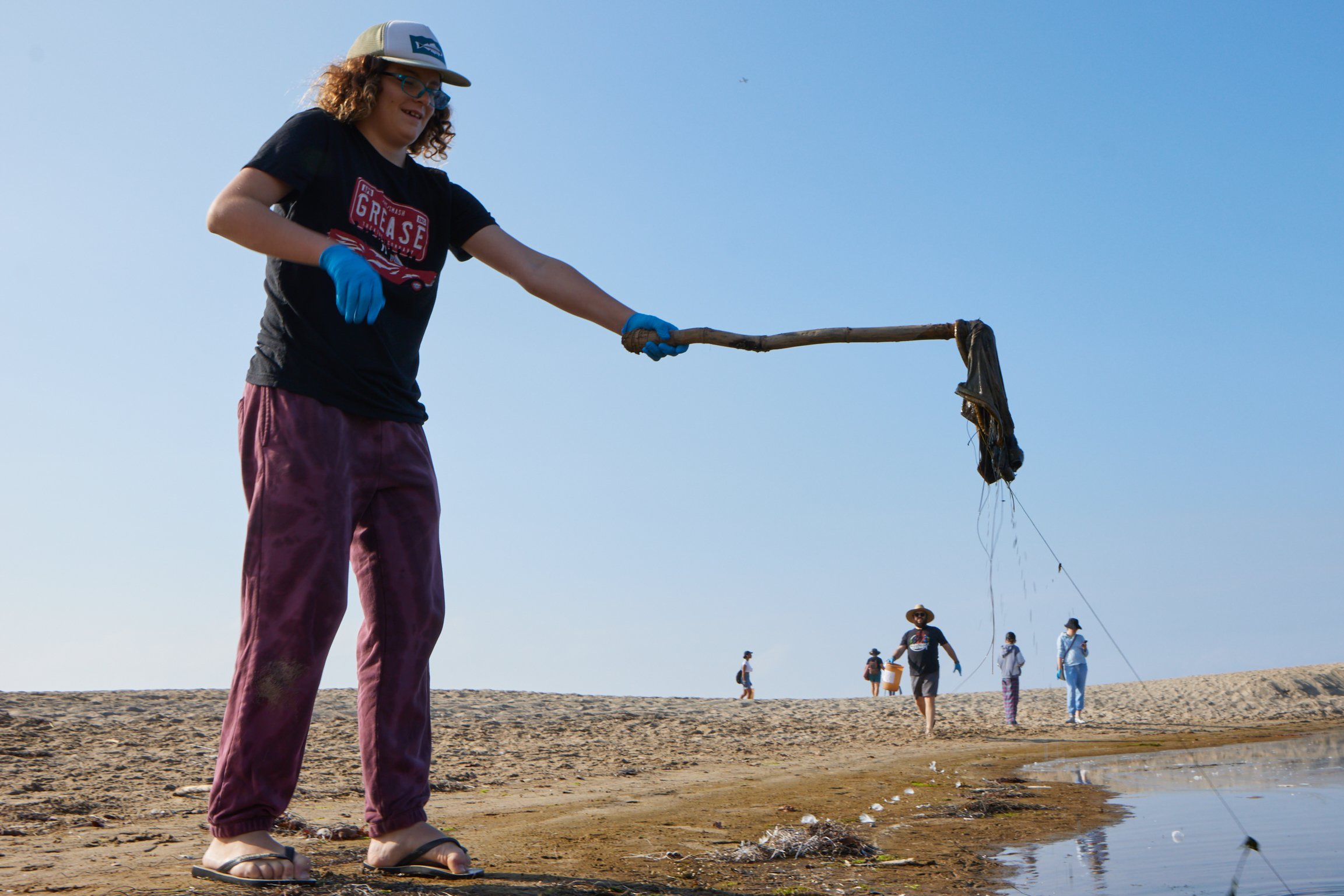  Volunteer Xavier successfully picks up a piece of trash from a lagoon during a coastal beach cleanup organized by Santa Monica College Sustainability Center at The Inkwell, Santa Monica, Calif., on Sept. 23, 2023. The heavily polluted lagoon is fed 