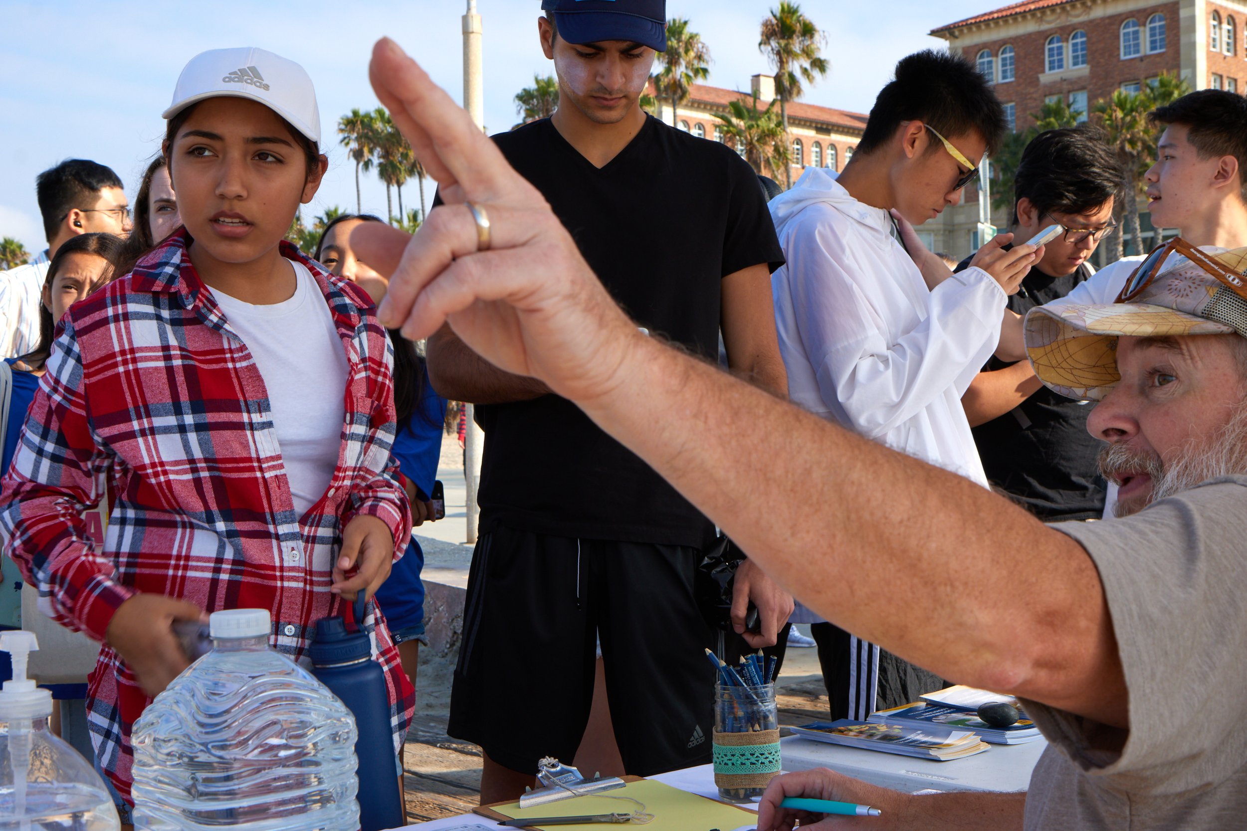  Gene Collins, right, point towards cleaning supplies for Luna, left, during a beach cleanup organized by Santa Monica College Sustainability Center at the Inkwell, Santa Monica, Calif., on Sept. 23, 2023. Luna had just finished signing the waiver fo