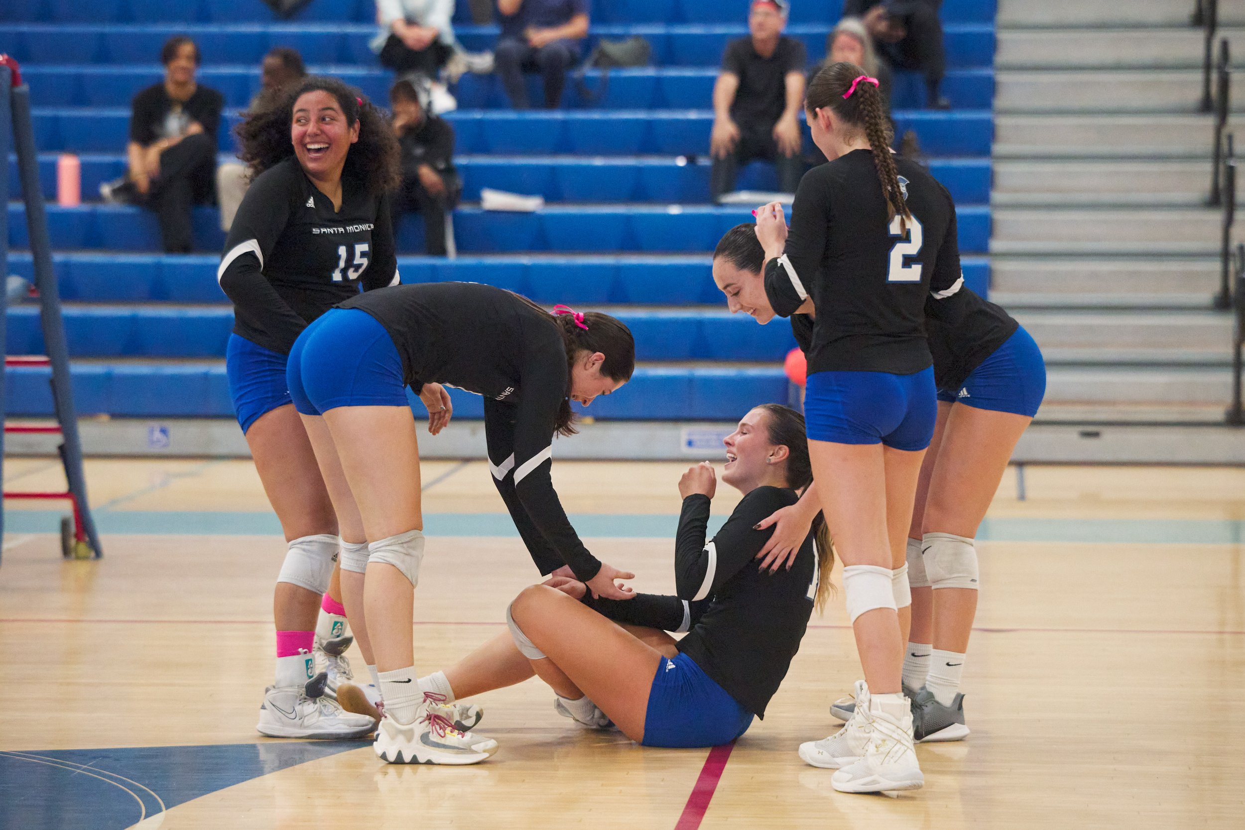  Santa Monica College Corsairs' Jaylynn Fierro, Maiella Riva, Natalie Fernandez (rear right), and Prior Borick (2) gather around and laugh with Mia Paulson (seated) after she got smacked in the face with the ball during the women's volleyball match a