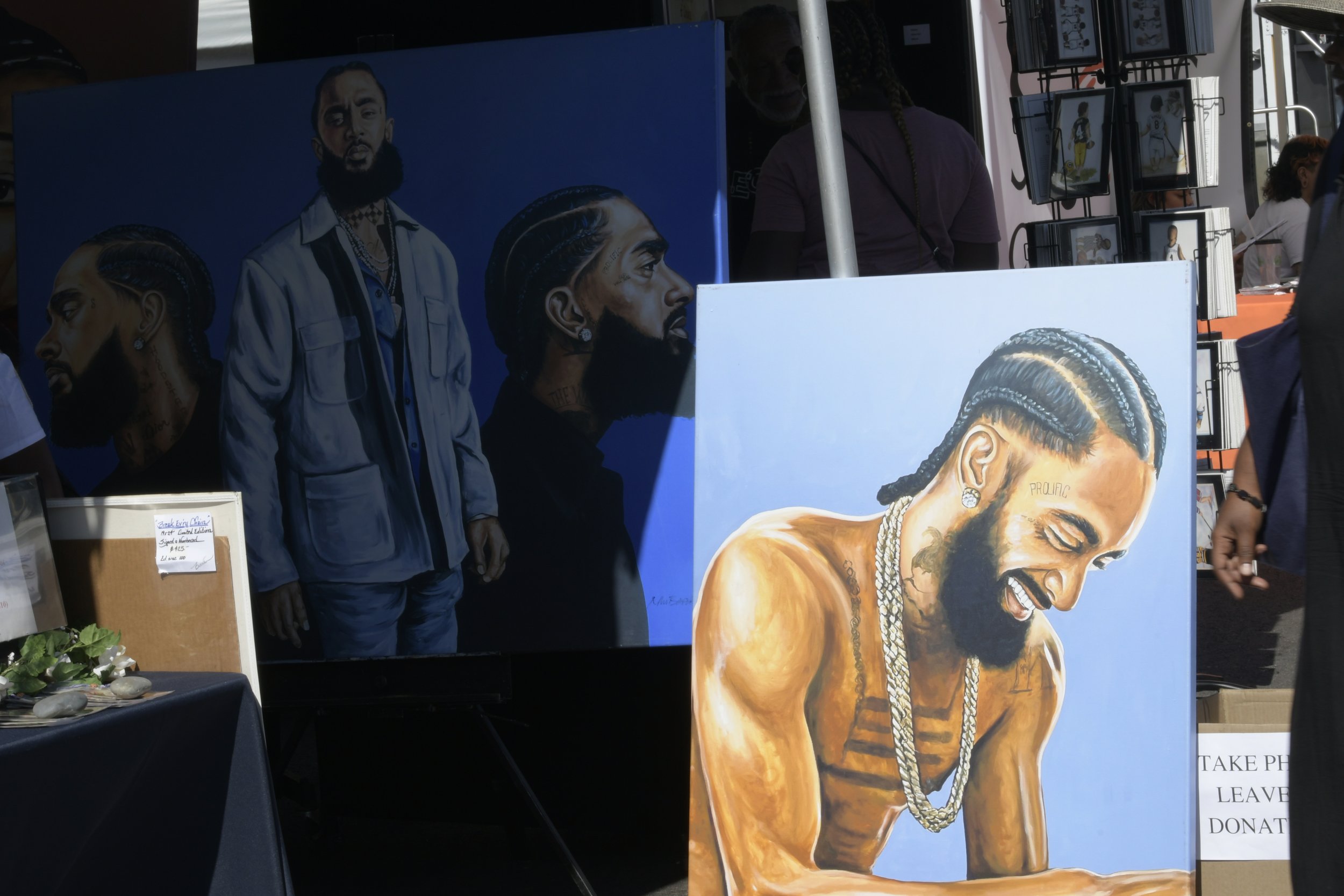  Two paintings on display featuring late LA icon Nipsey Hussle. (Mikey Duro | The Corsair) 