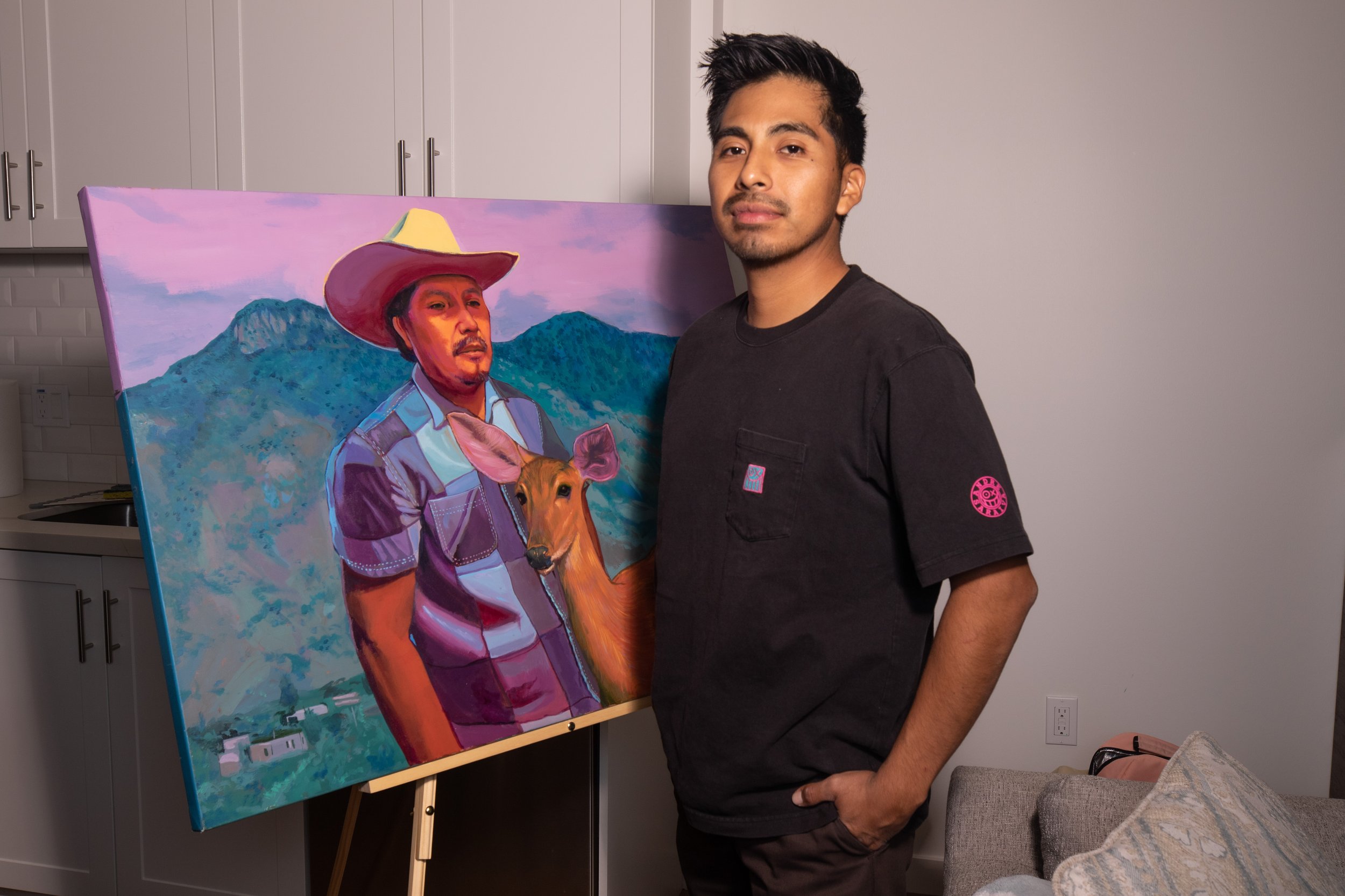  Oscar Lopez, Los Angeles artist and Santa Monica College alumni, at his home in Los Angeles, Calif. on Friday, Nov. 3, 2023. He stands in front of a painting depicting his father. (Akemi Rico | The Corsair) 