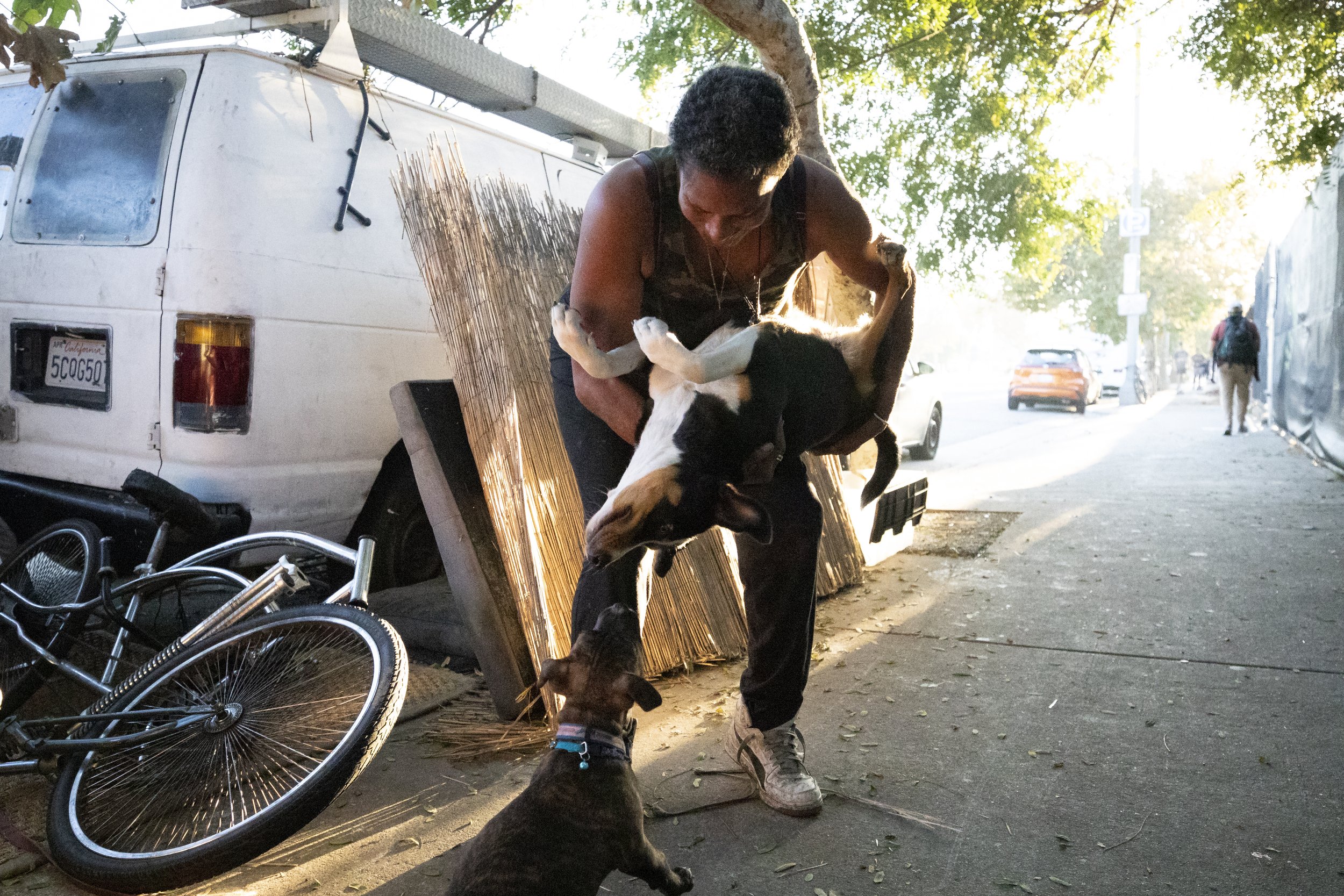  Rebecca Dannenbaum holds her dog, Google, upside down while she sniffs Dannenbaum’s new puppy, Snapchat, in near the RV she lives in on Venice Blvd. in Los Angeles, Calif., on Nov. 5, 2023. (Caylo Seals | The Corsair) 