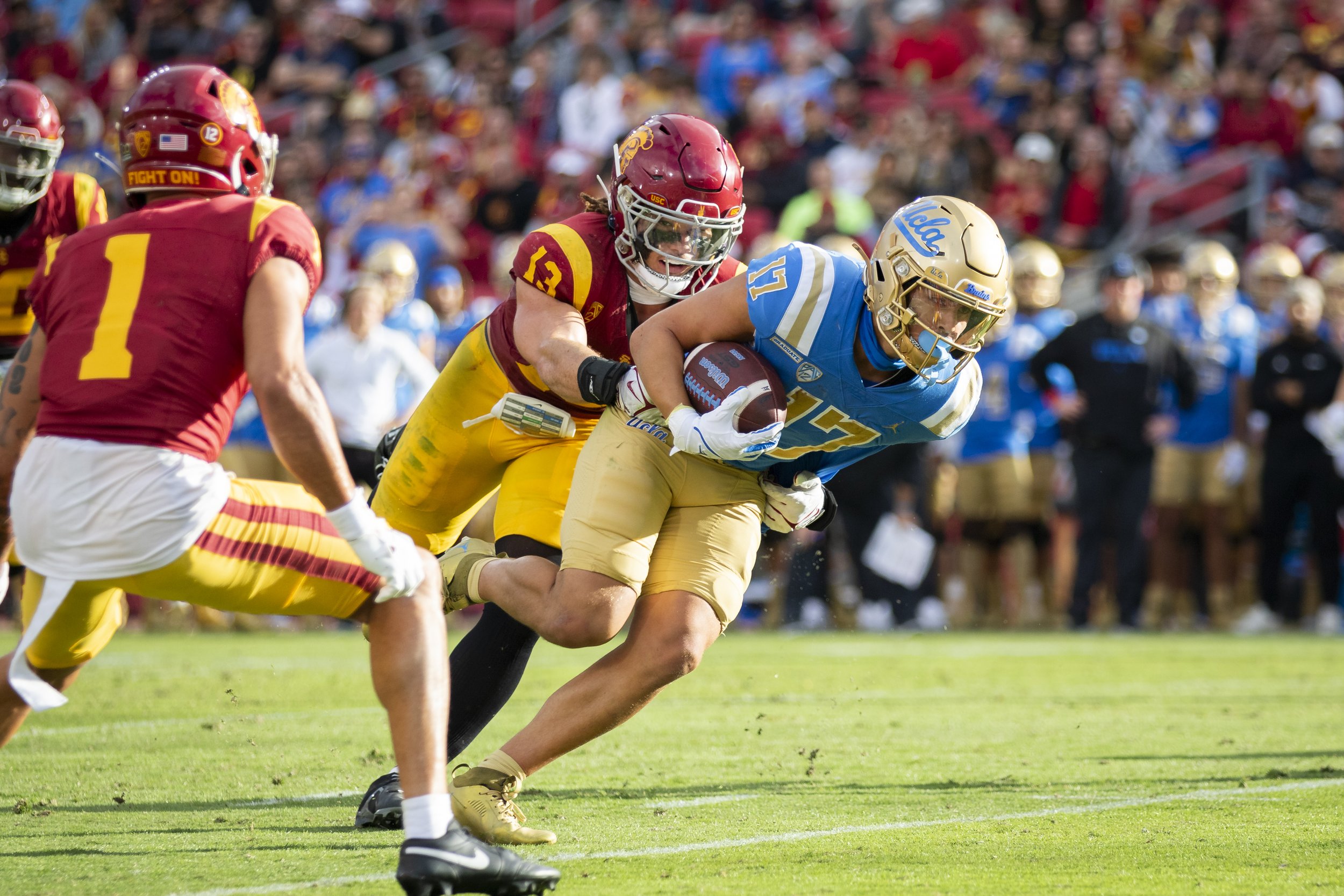  University of Southern California (USC) Trojan  middle linebacker Mason Cobb (center left) tackling University of California, Los Angeles (UCLA) Bruin wide receiver Logan Loya (center right) during the third quarter of a football game at the Los Ang