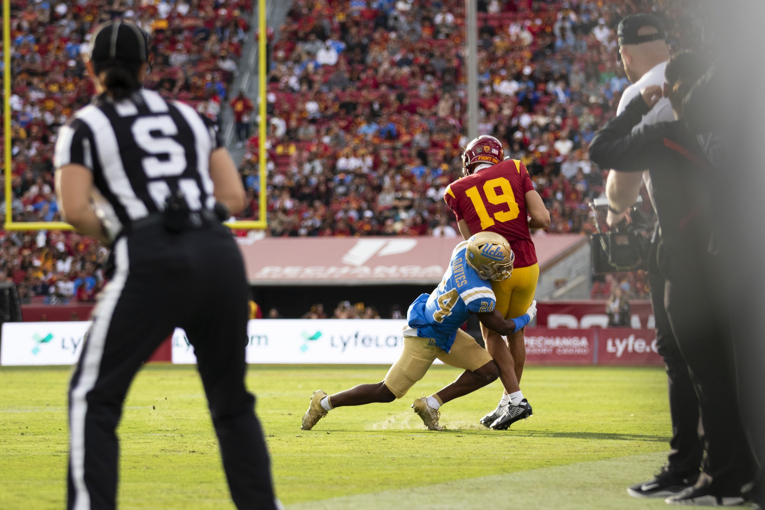  University of California, Los Angeles (UCLA) Bruin defensive back Jaylin Davies (left) tackling University of Southern California (USC) Trojan wide receiver Duce Robinson (right) during the third quarter of a football game at the Los Angeles Memoria