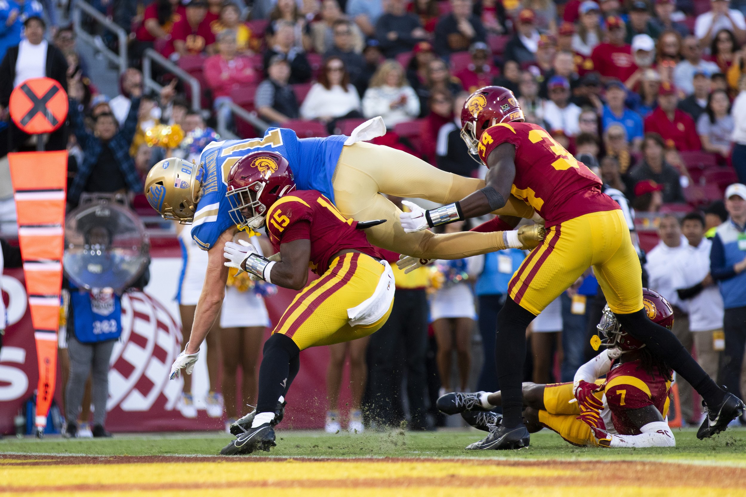  University of California, Los Angeles (UCLA) Bruin tight end Hudson Habermehl (left) being tackled into the end zone by University of Southern California (USC) Trojan safety Anthony Beavers Jr. (center) and rush end Braylan Shelby (right) during the