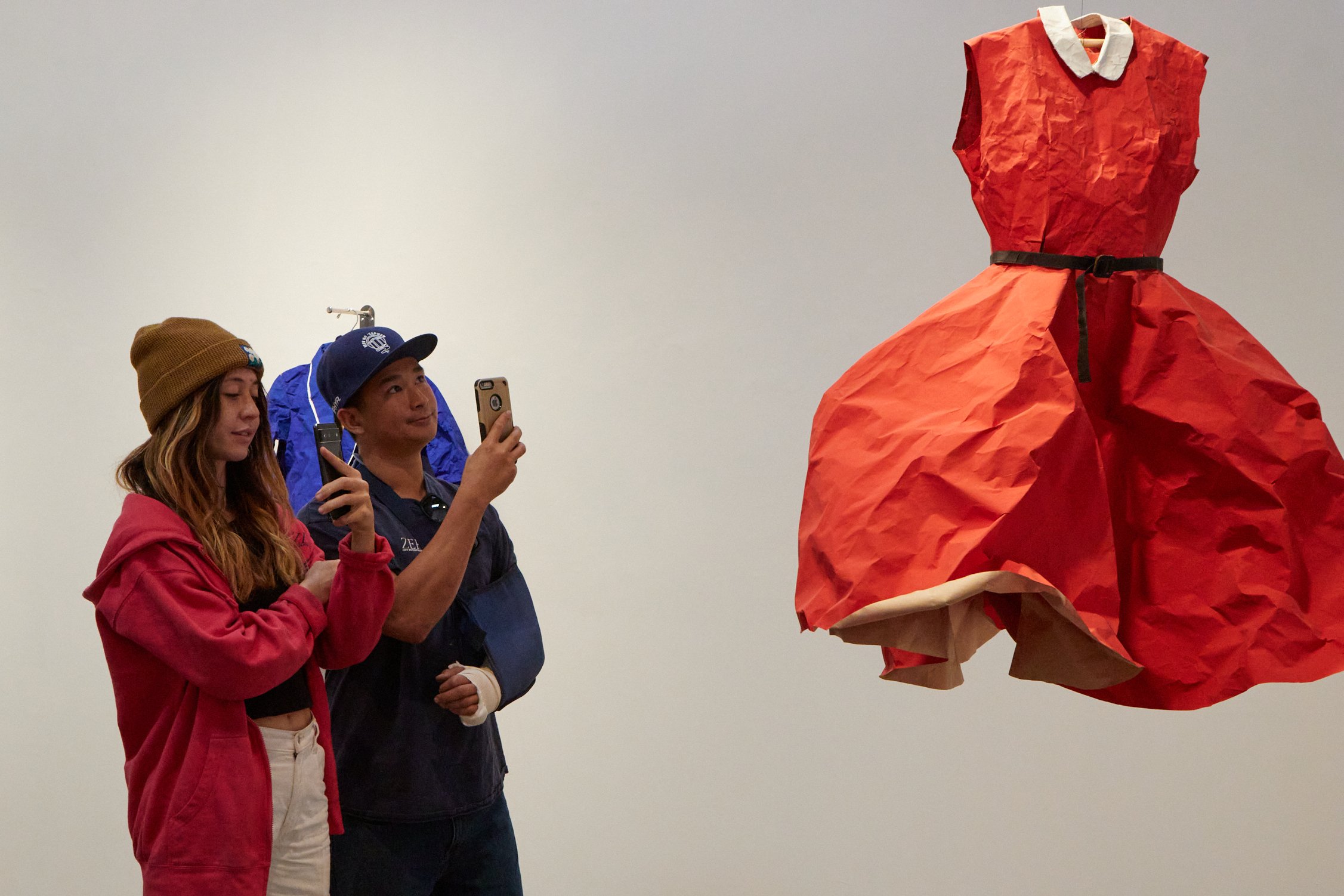  Asia Cruz (left) and Jonathan Vu (right) takes a picture of a red dress from Phranc's childhood in her art exhibition The Butch Closet in Craig Krull Gallery at Bergamot Station Arts Center, Santa Monica, Calif., on Nov. 4, 2023. The clothes that ha
