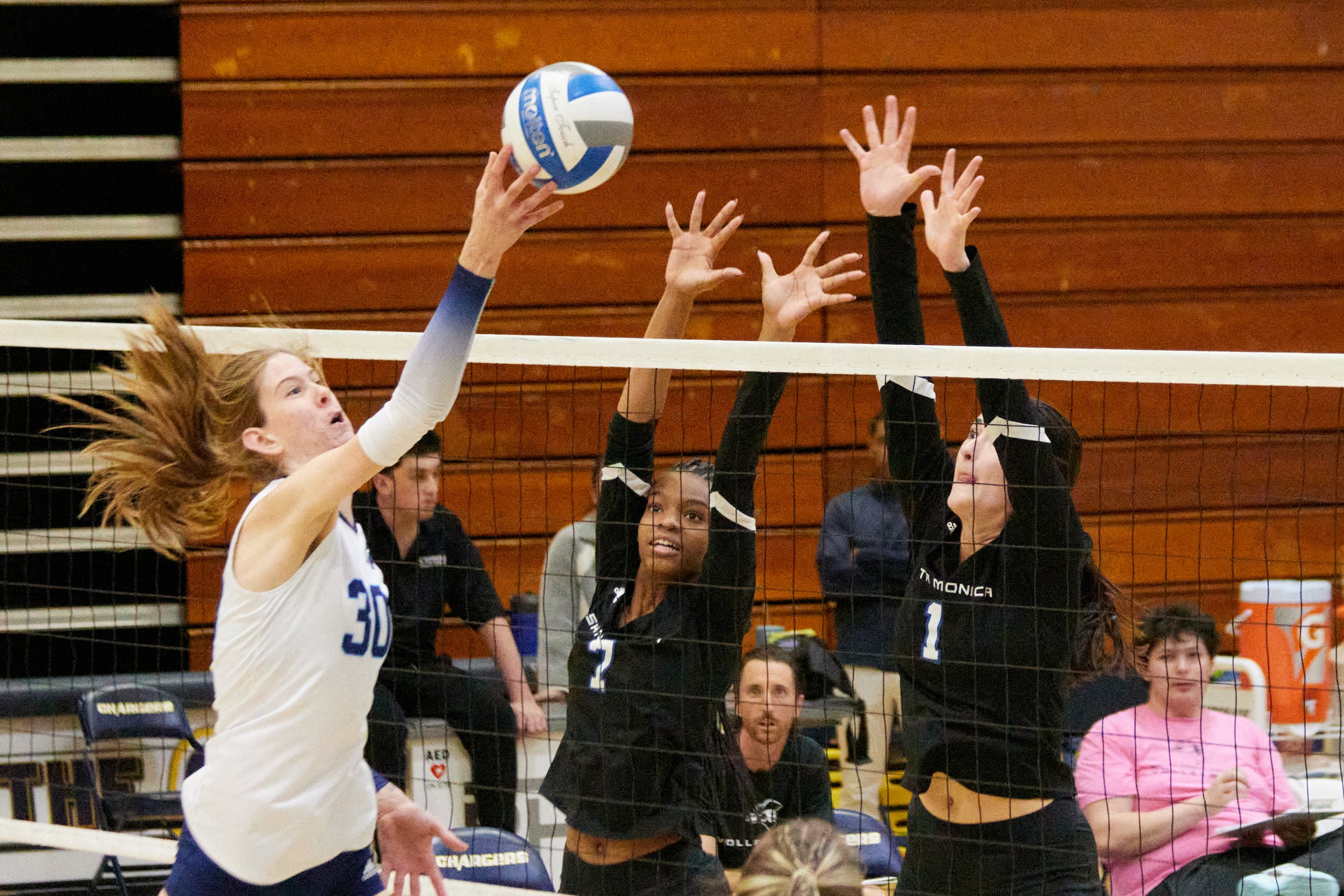  Santa Monica College Corsairs opposite hitter Zarha Stanton (center) and outside hitter Maiella Riva (right) attempts to block a shot from Cypress College Chargers opposite hitter Zoe Ziegler (left) during the women's volleyball match against each o