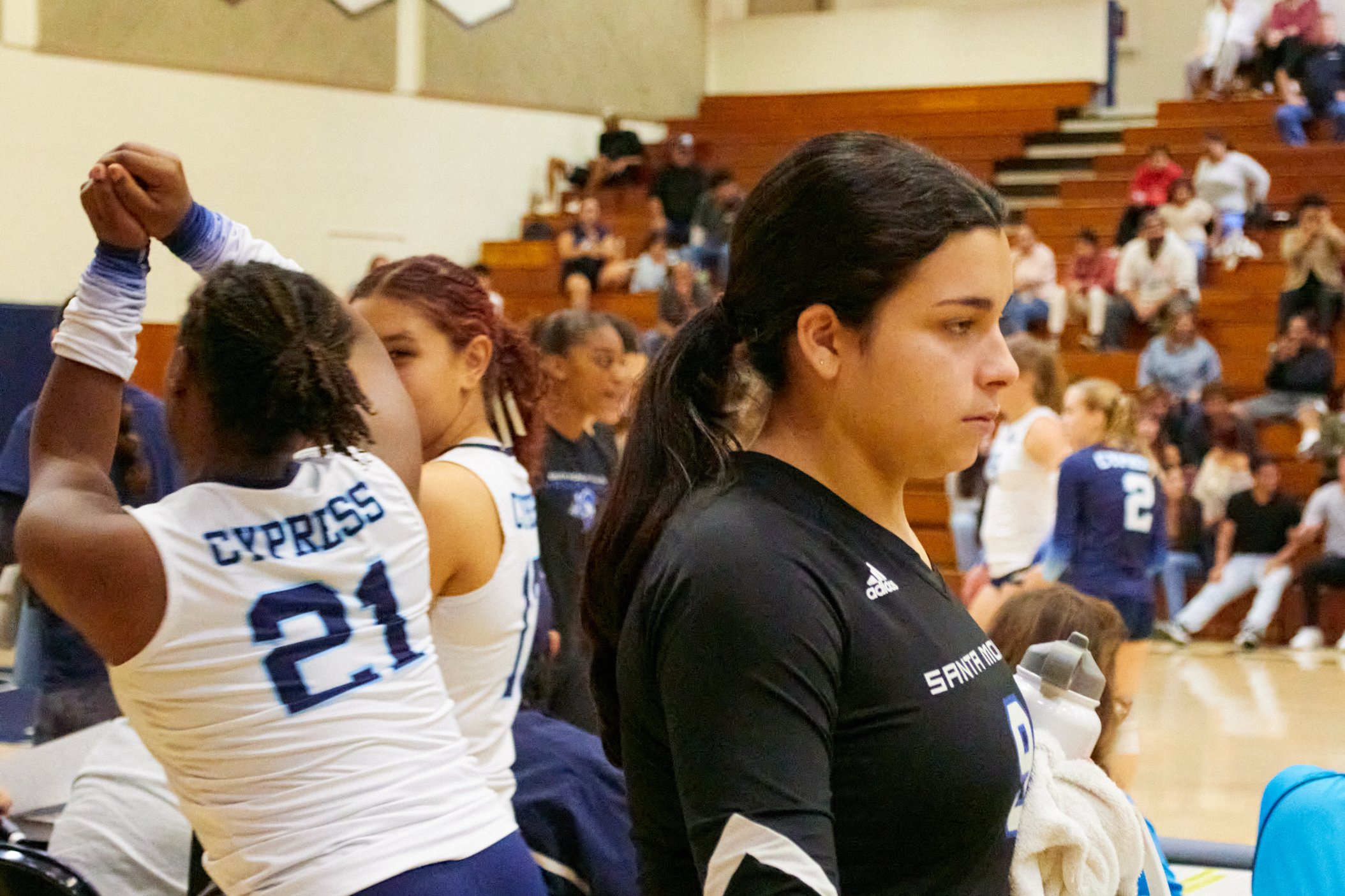  Santa Monica College Corsairs middle blocker Adriana Brady (right) walking past Cypress College Chargers outside hitter Zariah Honeycutt (no. 21) and opposite hitter Kaitlyn Emma Casino (no. 17) during the women's volleyball match against each other