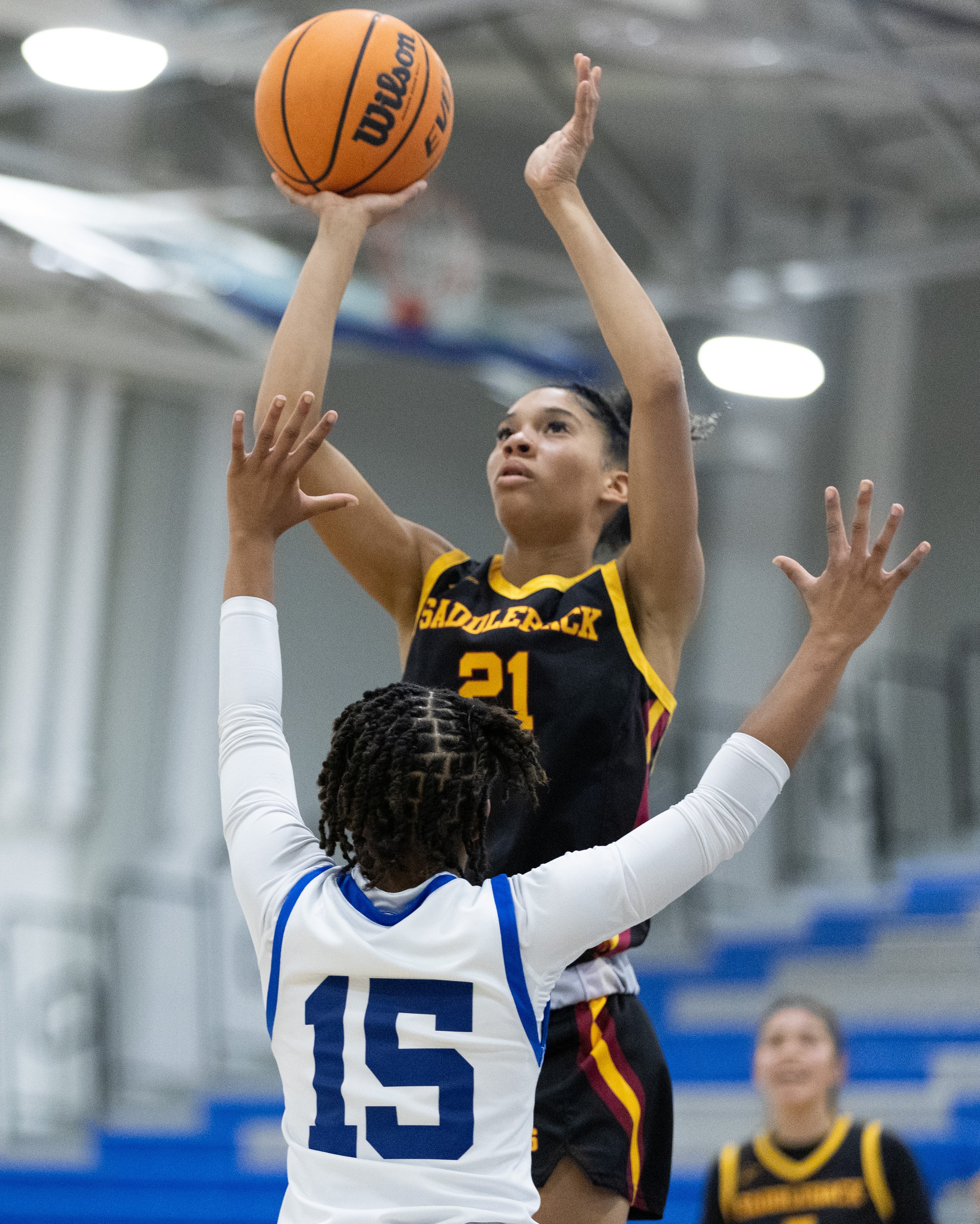  Alex Surrena-Thompson(21) from Saddleback Callege taking a shot to net as Santa Monica College(SMC) Corsair Jaiyahne Henderson(15) attempts to block the shot in the SMC Pavillion Gym at Santa Monica, Calif. Corsairs lost 62-50 to put them in a 3-gam