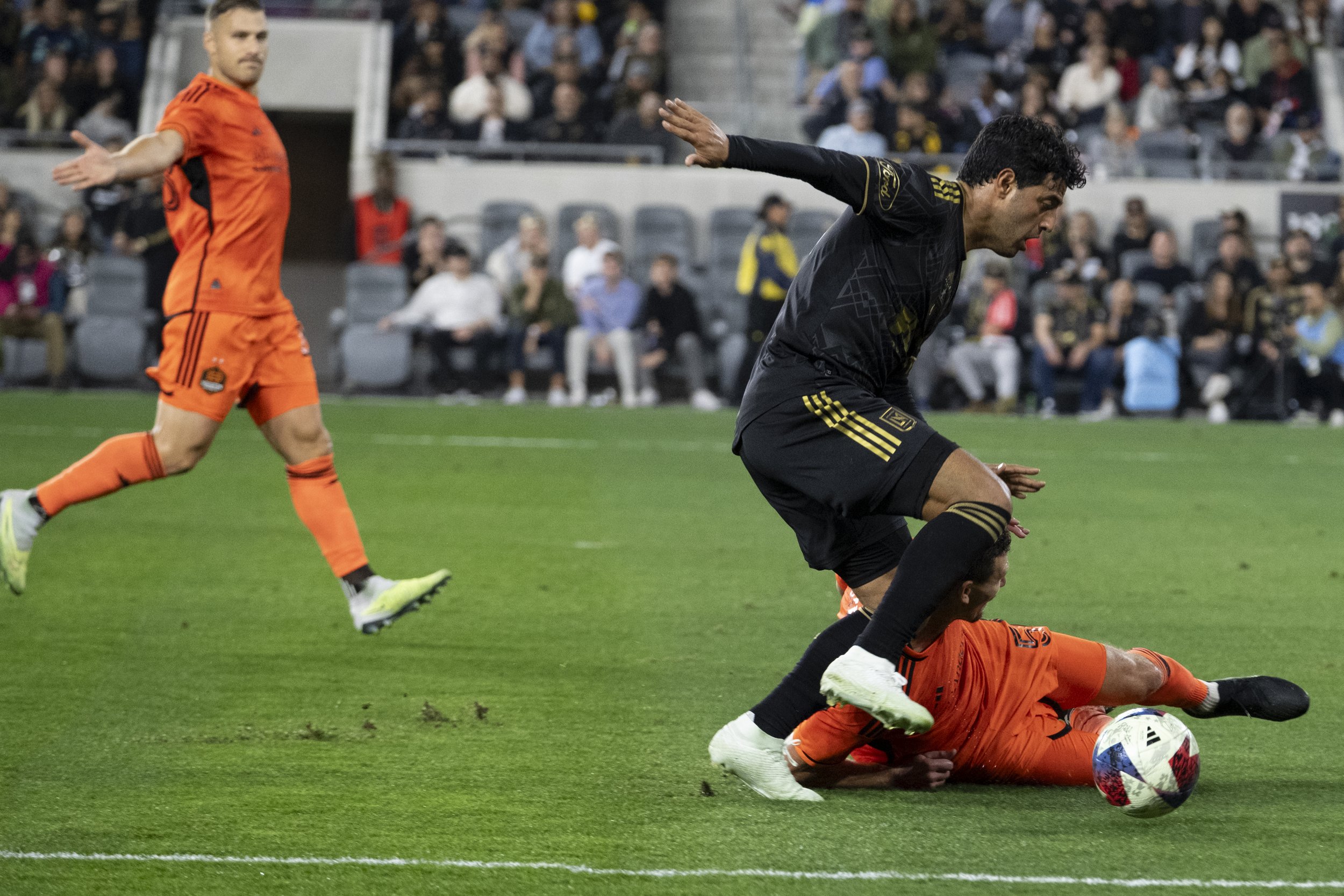  Carlos Vela, Forward #10 of LAFC, and Daniel Stores Defender #5 of the Houston Dynamo run for the ball during the Major League Soccer (MLS) match on Wednesday, June 14, at the Bank of Montreal (BMO) Stadium in Los Angeles, California. (Anna Sophia M