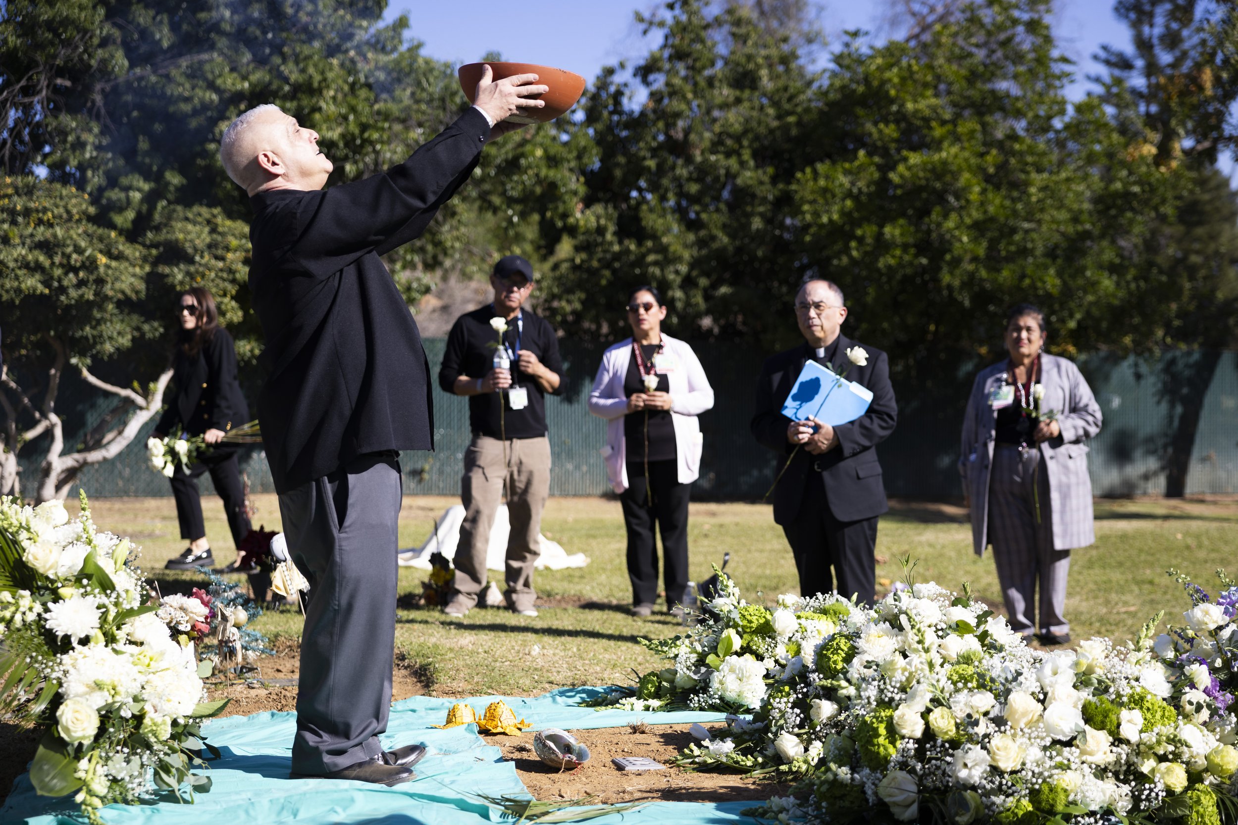  One of the religious leaders at the Los Angeles County Ceremony of the Unclaimed Dead holds a bowl of incense over his head at the LA County Cemetery, in Los Angeles, Calif., on Thursday, Dec. 14, 2023. The interfaith ceremony honored 1,937 individu