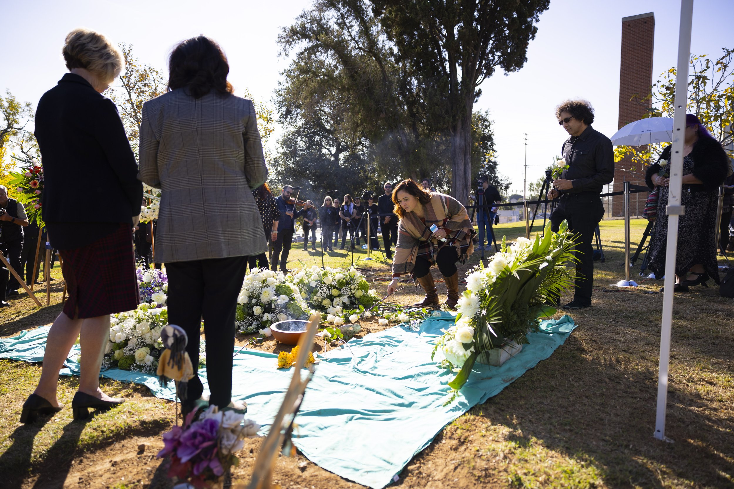  Guests attending the LA County Ceremony of the Unclaimed Dead place white roses on the grave marking the 1,937 individuals who died in 2020 and either did not have next of kin, or were not claimed by their next of kin at the LA County Cemetery, in L