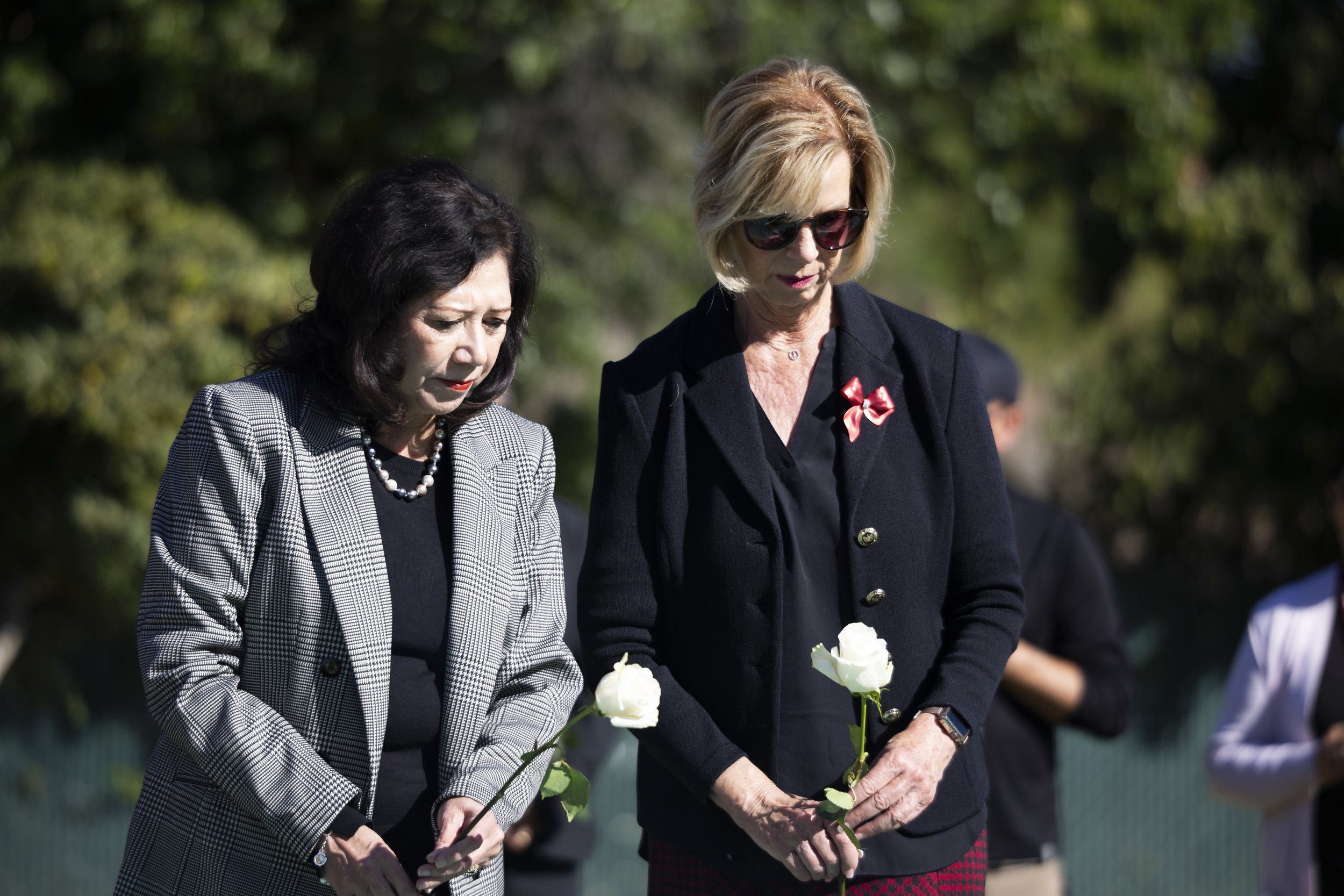  Los Angeles County Supervisor Hilda Solis (left, first district) and Janice Hahn (fourth district) place white roses on the grave marking the unclaimed dead from 2020 during the LA County Ceremony of the Unclaimed Dead at the LA County Cemetery, in 