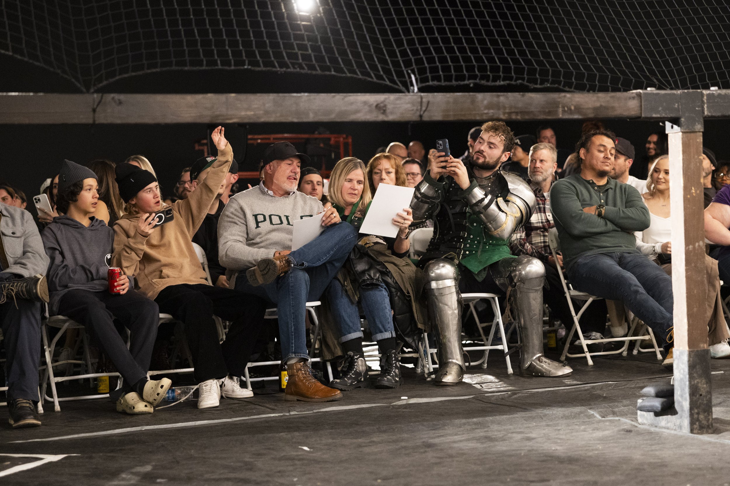  Audience members watch buhurt fighters clash during Golden Ring II in Burbank, Calif., on Saturday, Dec. 16, 2023. Buhurt, otherwise known as armored combat, is a full contact fighting sport which fighters use armor and weapons that are historically