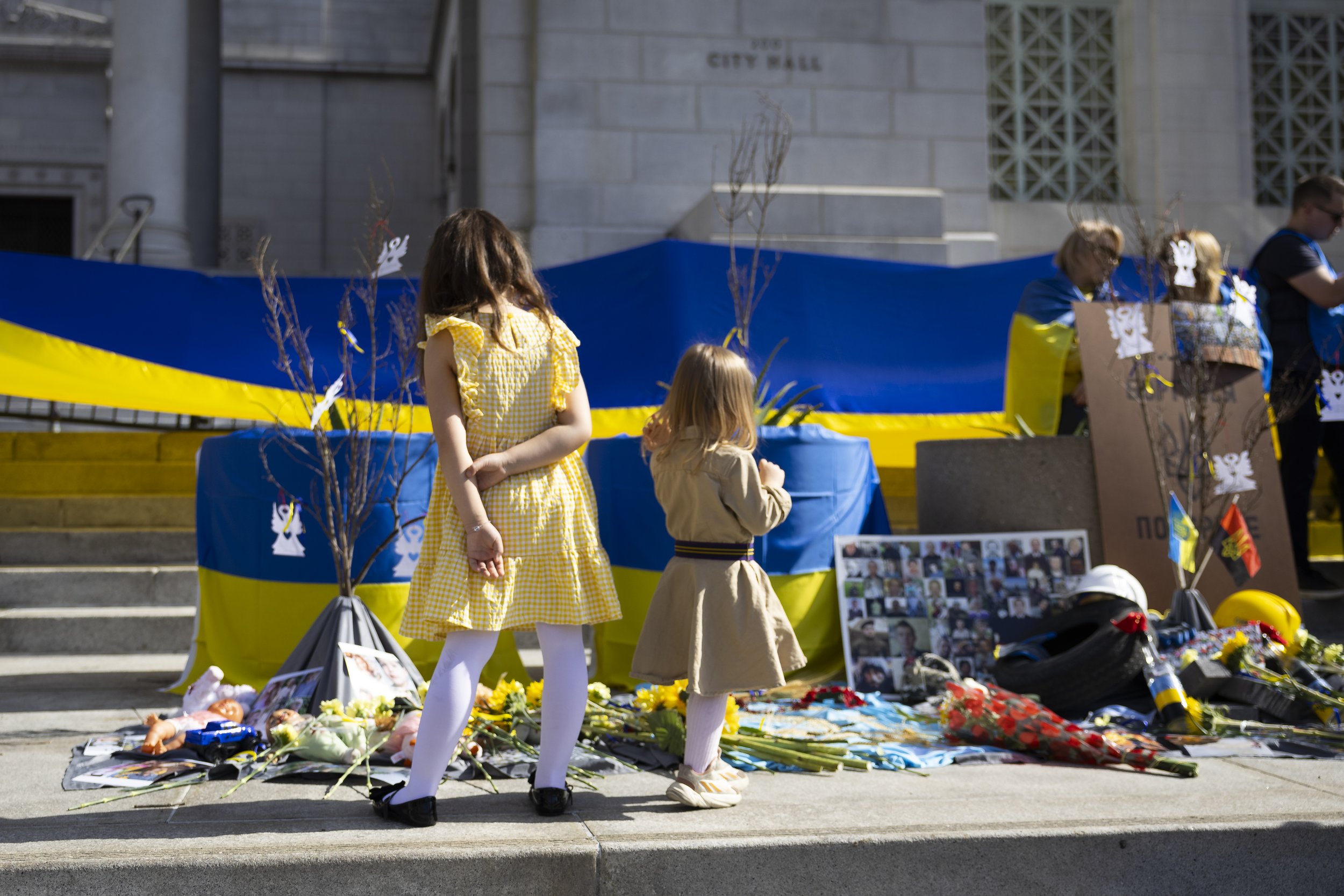  Two children look at the moving art installation during a protest organized by Stand With Ukraine Foundation outside Los Angeles City Hall, Los Angeles, Calif., on Saturday, Feb. 24, 2024. The protest was held because it is the two year anniversary 
