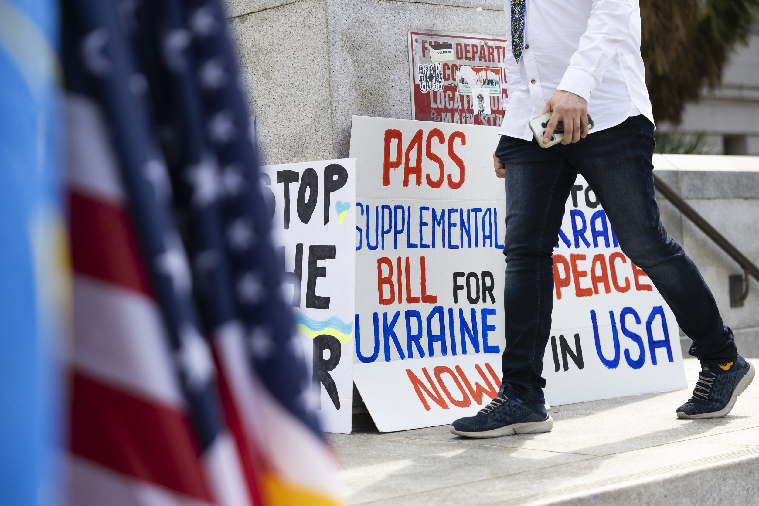  A person walks past signs and flags which will be used in the upcoming protest outside Los Angeles City Hall, Los Angeles, Calif., on Saturday, Feb. 24, 2024. The protest was held because it is the two year anniversary of the start of Russia-Ukraine