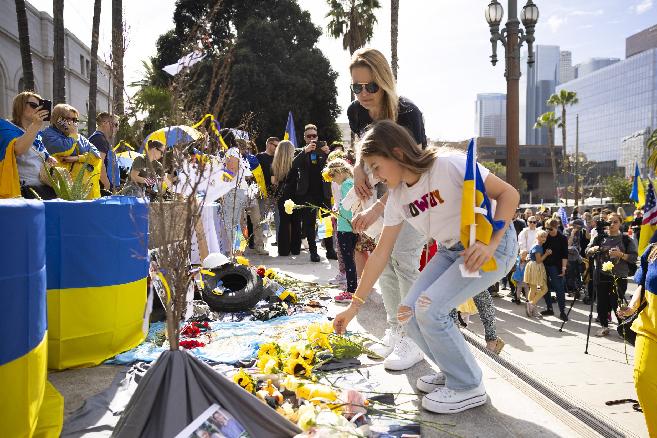  Protesters place flowers on the moving art installation before the protest starts outside Los Angeles City Hall, Los Angeles, Calif., on Saturday, Feb. 24, 2024. The protest was held because it is the two year anniversary of the start of Russia-Ukra