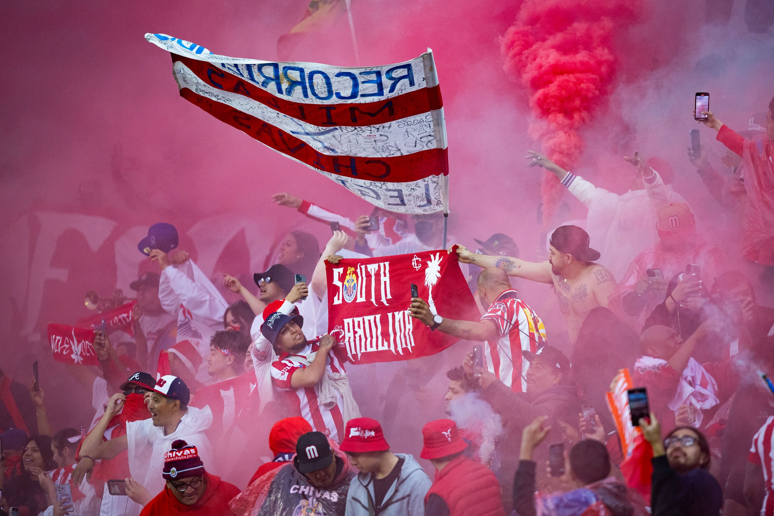  Club Deportivo Guadalajara (Chivas) fans hold flags, signs, smoke bombs, and flares during the second half of El Clásico Tapatio 2024 at BMO Stadium in Los Angeles, Calif. on Sunday, March 24, 2024. Many flares and smoke bombs were thrown onto the f