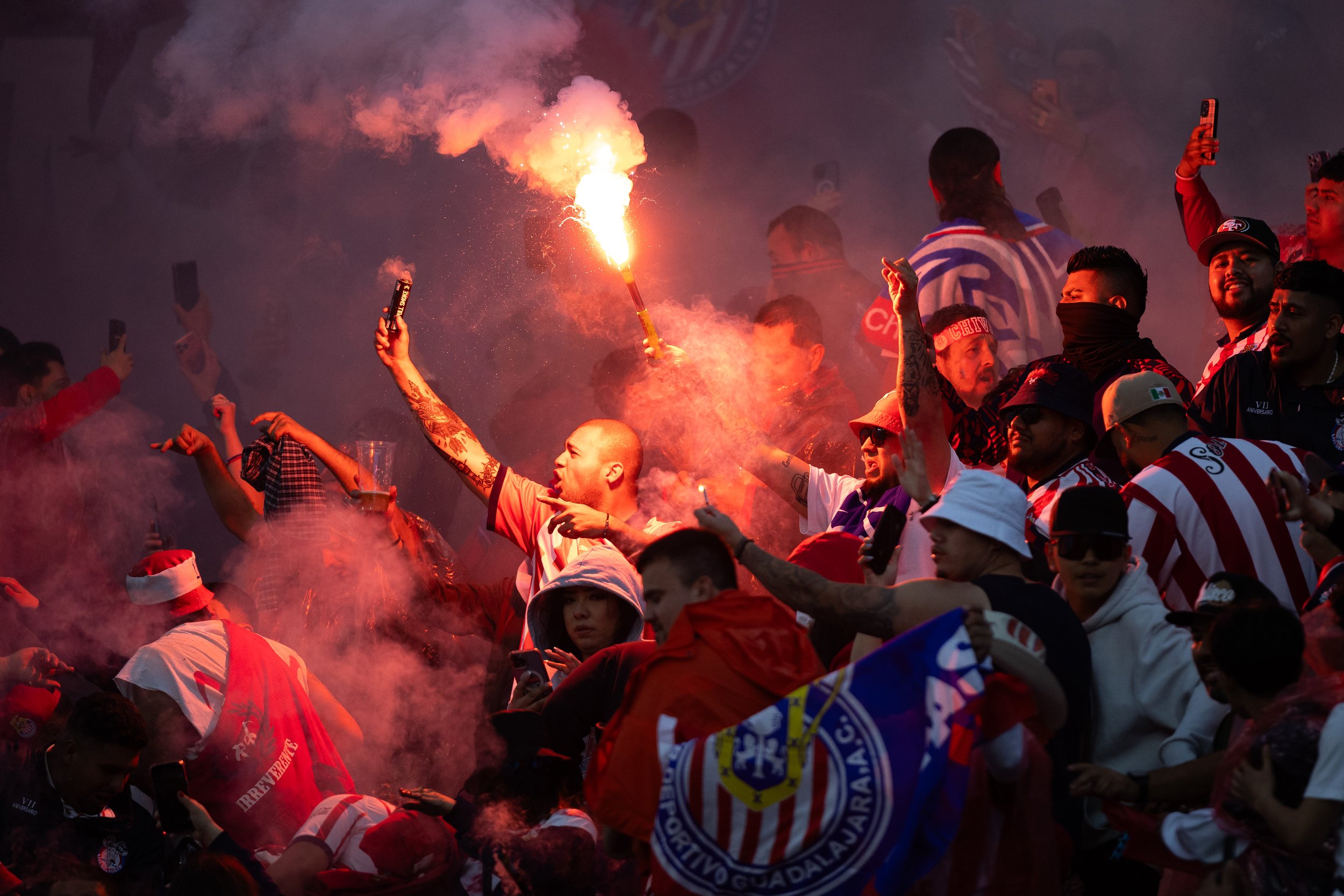  Club Deportivo Guadalajara (Chivas) fans hold flags, signs, smoke bombs, and flares during the second half of El Clásico Tapatio 2024 at BMO Stadium in Los Angeles, Calif. on Sunday, March 24, 2024. Many flares and smoke bombs were thrown onto the f