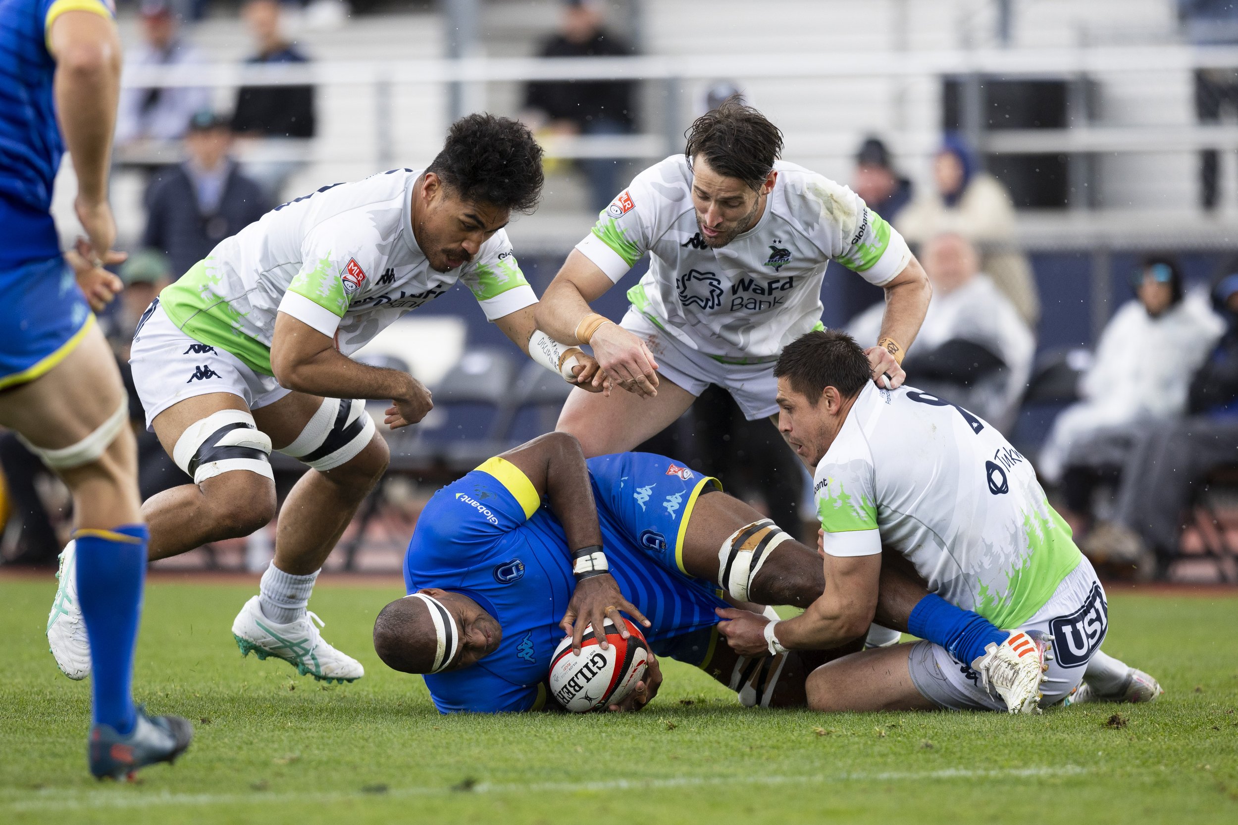  Seattle Seawolves flanker Haini Pagopagohokma (left), fly half Samuel Windsor (upper center), and scrum half Juan-Phillip Smith (right) tackle and attempt to steal the ball from Rugby Football Club Los Angeles lock Semi Kunatani (lower center) durin