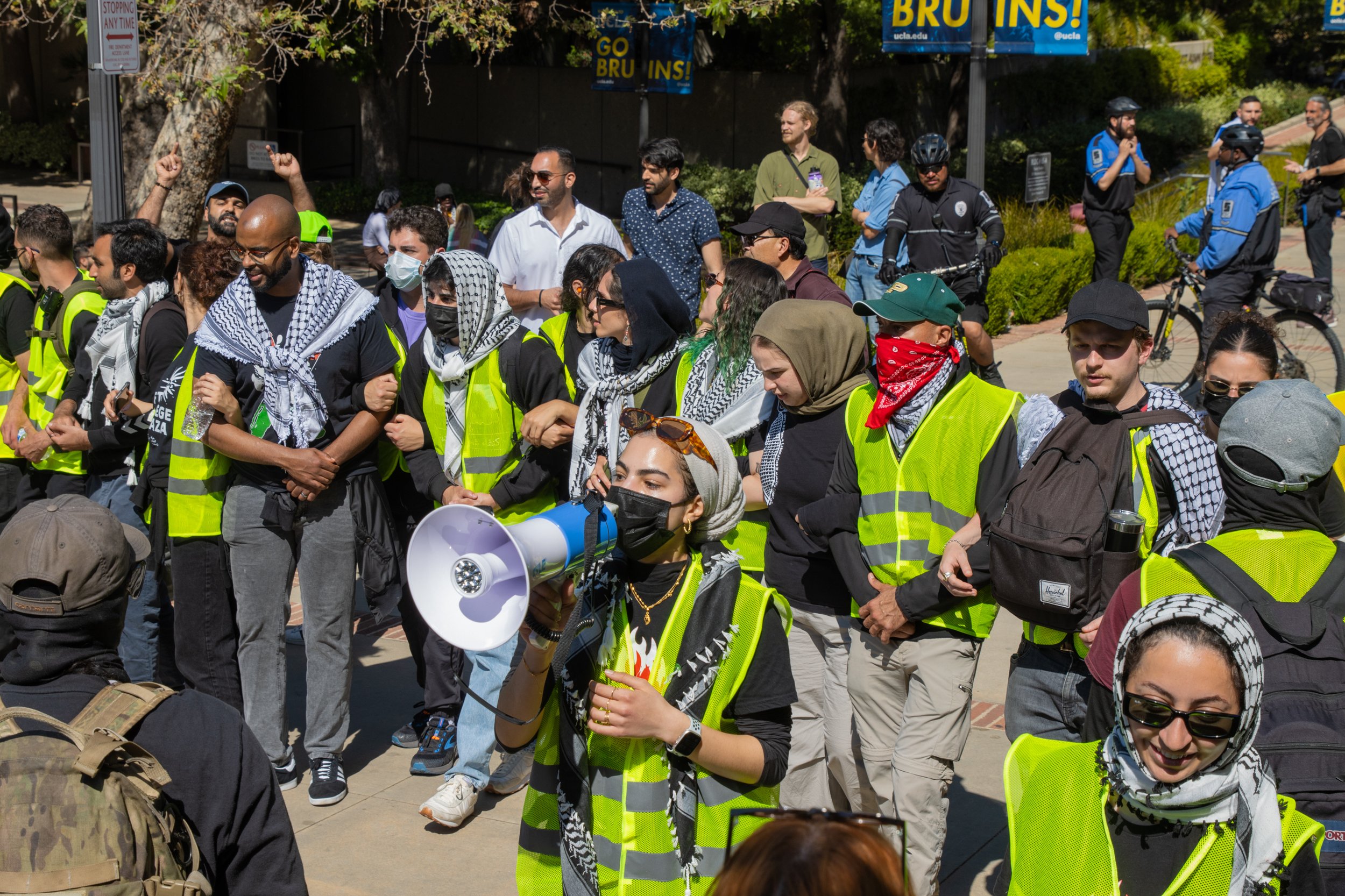  Pro-Palestine protestors chant while human barrier formed by students and staff divides them from Israeli supporters at University of California, Los Angeles, Calif. Sunday, April 28, 2024 (Libna Florencio | The Corsair) 