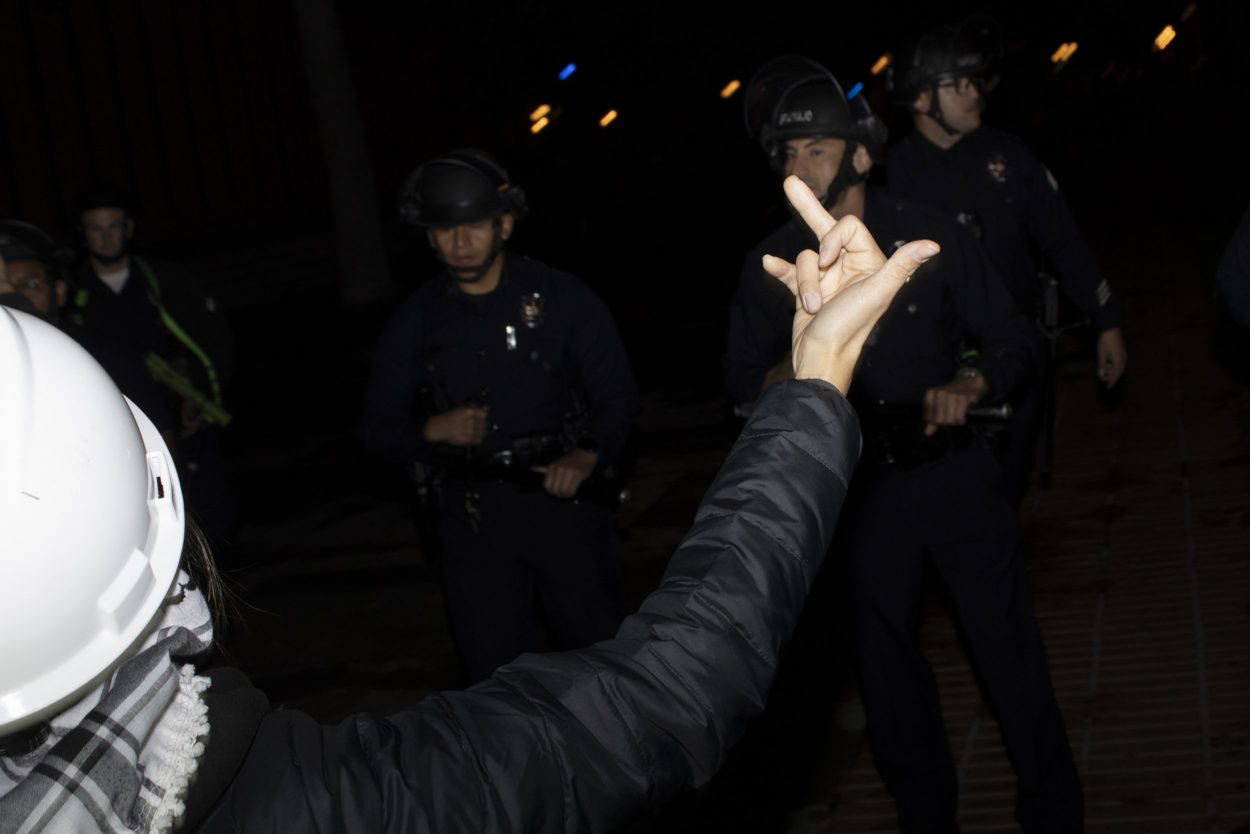  A protester from the University of Southern California Divest from Death coalition holds up a middle finger while starring down the University of Southern California Department of Security after being told to disperse on Sunday, May 5, 2024, at The 