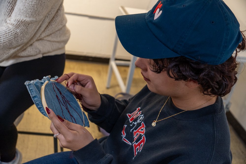  SMC Student on Denim Day  enjoying their time embroidering an intrinsic design onto a piece of denim material. 