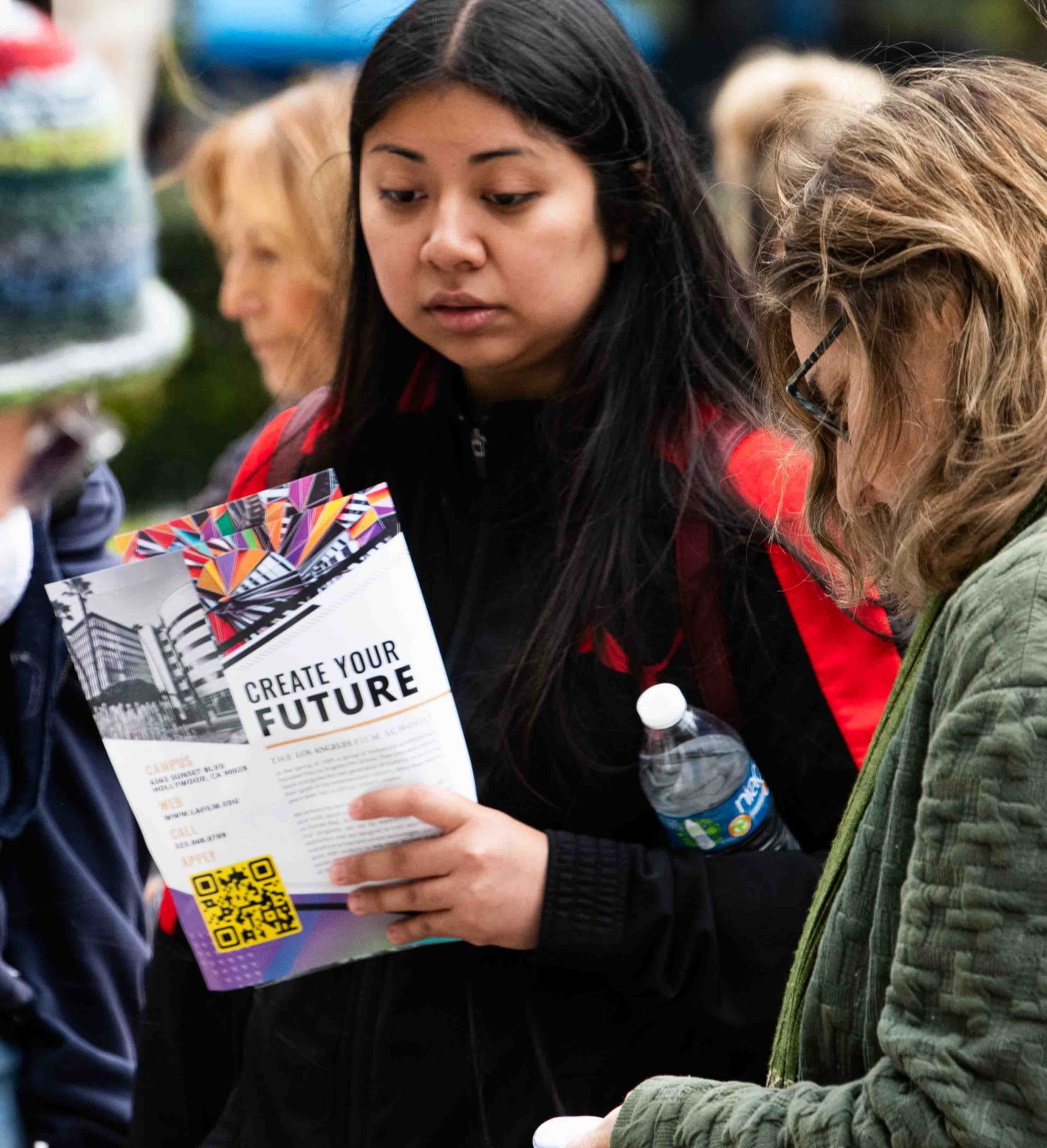  A Santa Monica College student reads a brochure to Los Angeles film school with the headline "Create Your Future" during the Santa Monica College fair on April 25,2024  in Santa Monica,Calif., (Corsair Photo:Jamael Shotomide) 
