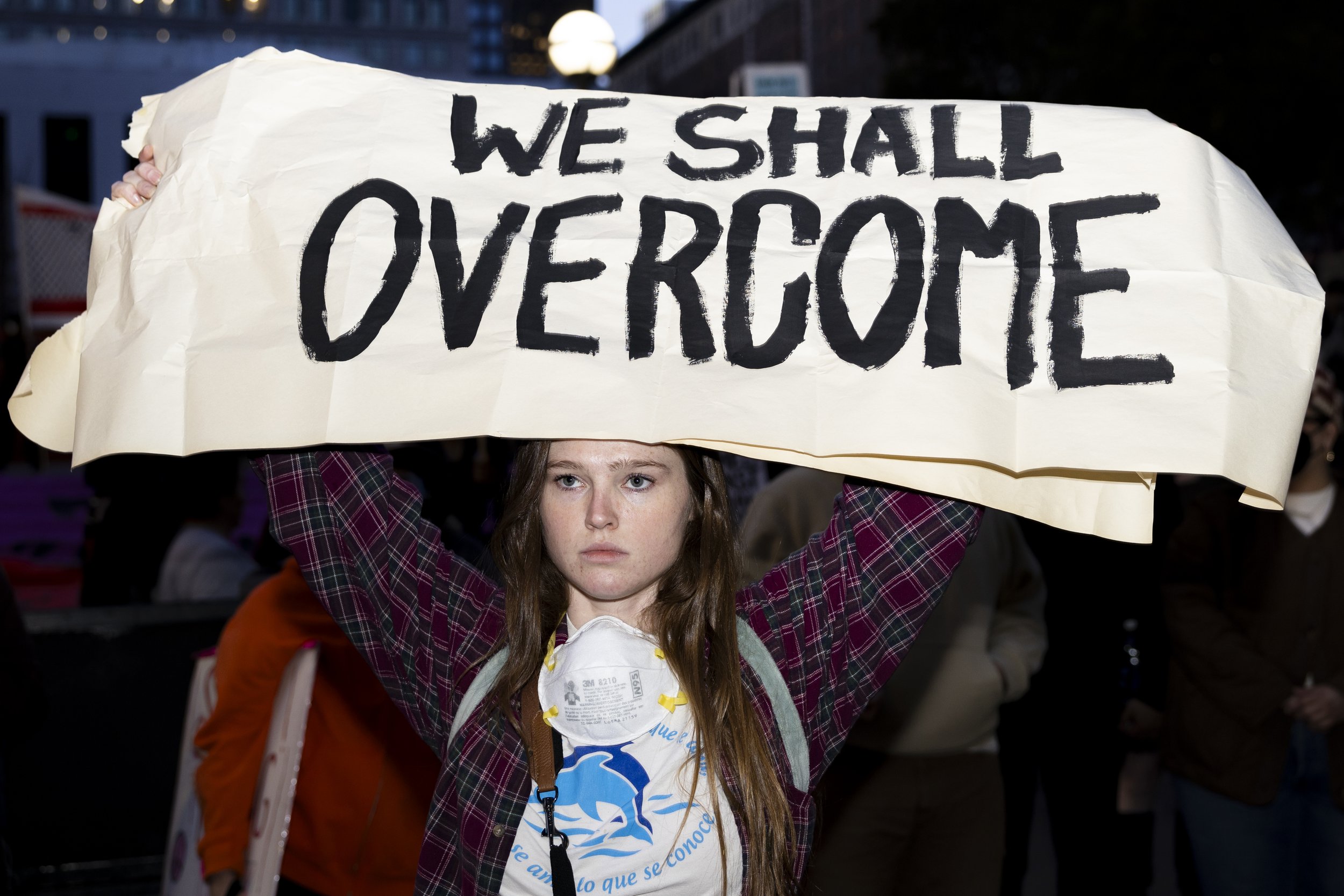 A protester holds a sign stating, “We Shall Overcome,” during the We Fight Back protest with the message of calling for the “defeat of Trump’s Extreme-Right Billionaire Agenda,” on Monday, January 20, 2025, at Pershing Square in downtown Los Angeles