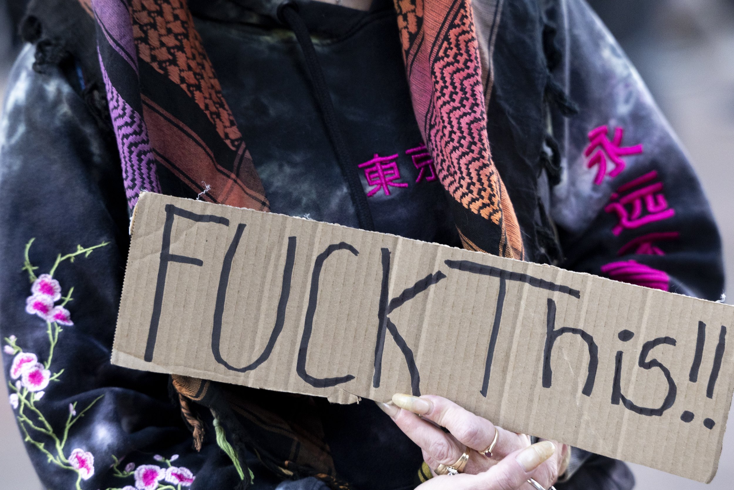 A protester holds a sign up that states, “Fuck this,” during the We Fight Back protest with the message of calling for the “defeat of Trump’s Extreme-Right Billionaire Agenda,” on Monday, January 20, 2025, in downtown Los Angeles, Calif. (Jake Crand