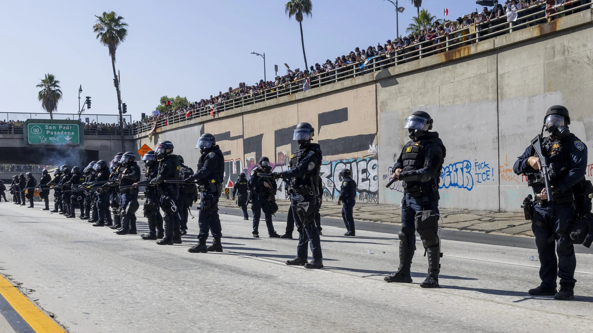 A California Highway Patrol officer prepares a formation to push back protesters off Highway 101 in Downtown Los Angeles, Calif., after several hundred activists overtook the highway during the third day of anti-ICE protests on Sunday, June 8, 2025.