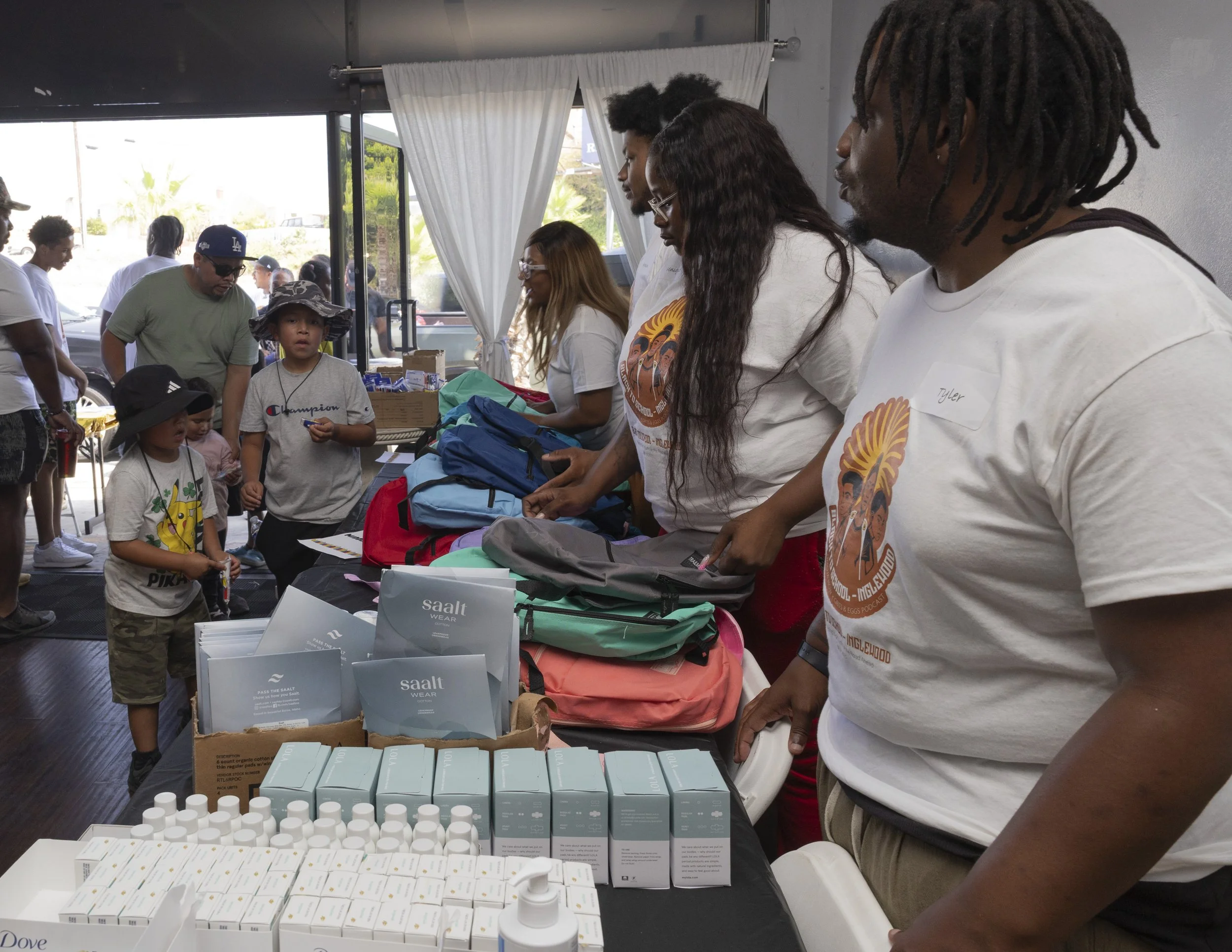 Tyler Jackson-Zeno (Front Right), an SMC alumnus, and three volunteers distributed back-to-school supplies at Umoja Now’s “Black To School– Inglewood: Resourcing Black Youth for the Road Ahead” mutual aid event inside Event Space Inglewood in Inglew