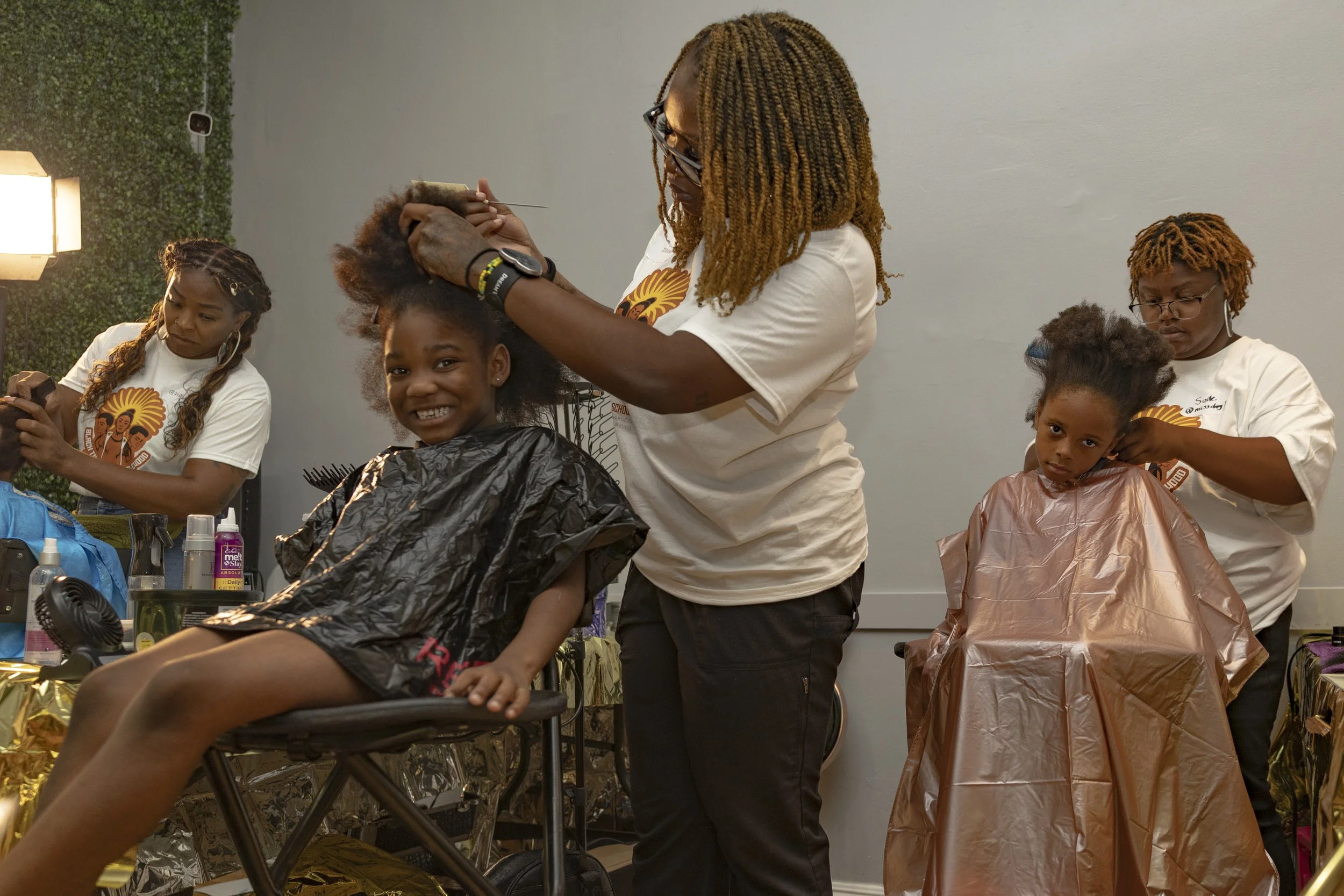 Stevenie Farmer (Left) and volunteers for a Umoja Now mutual aid event braided hair inside Event Space Inglewood in Inglewood, Calif., on Sunday, Aug. 10, 2025, preparing children for school in a historically marginalized city. (Kayjel J. Mairena |