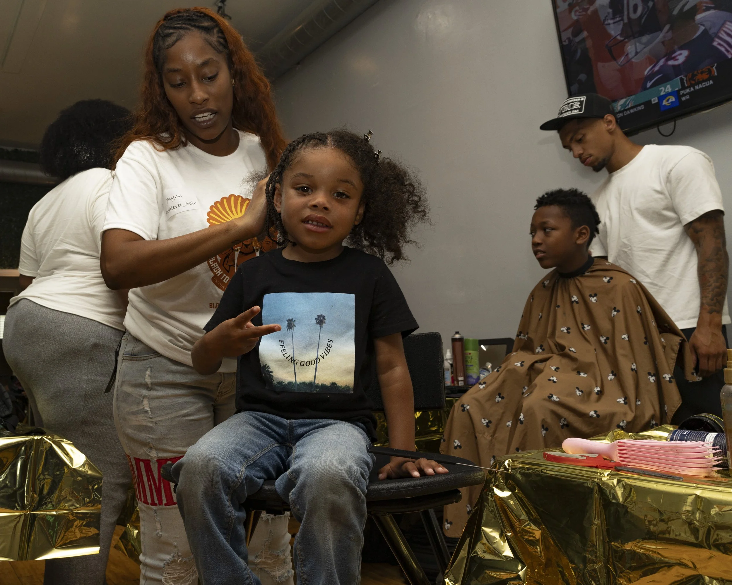 Jalynn Spann (Left) and Naishawn Jernijan (Right) providing hair services at a Umoja Now mutual aid event inside Event Space Inglewood in Inglewood, Calif., on Sunday, Aug. 10, 2025, preparing children for school in a historically marginalized city